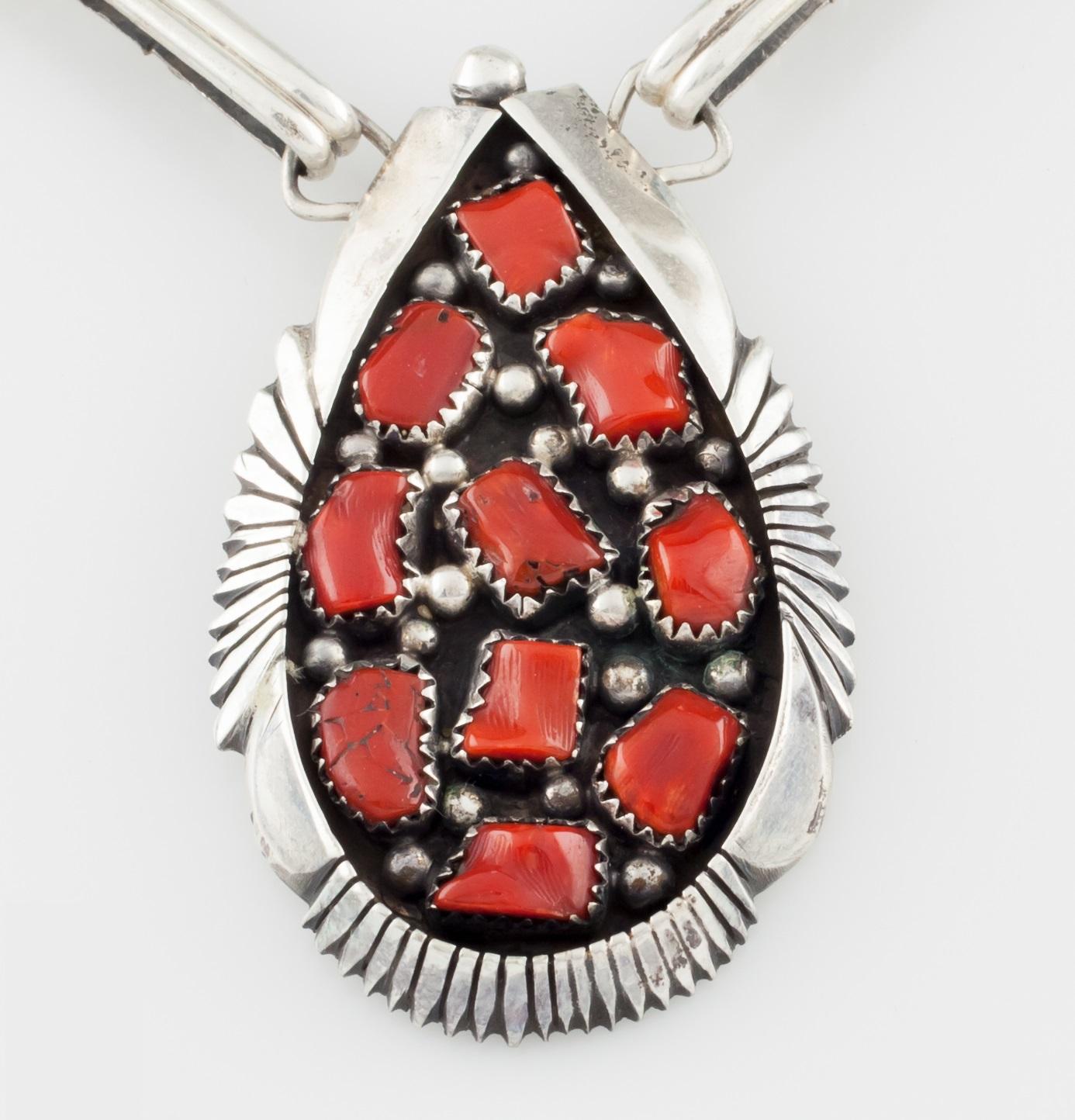 .925 Sterling Silver Native American Necklace 
Accented with 16 Coral stones (excluding centerpiece)
Center piece measures approximately: 1.25
