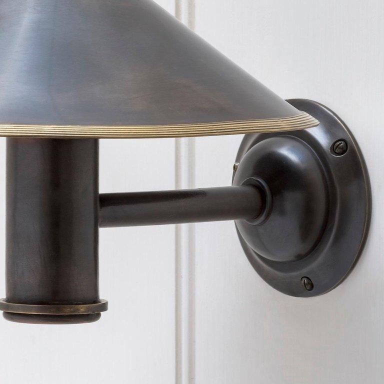 A 1920s inspired cast wall light with conical shade. Shown here with the reeded metal shade, can be supplied alternatively with a studded metal shade or glass coolie shade, in a variety of hand finishes.
 