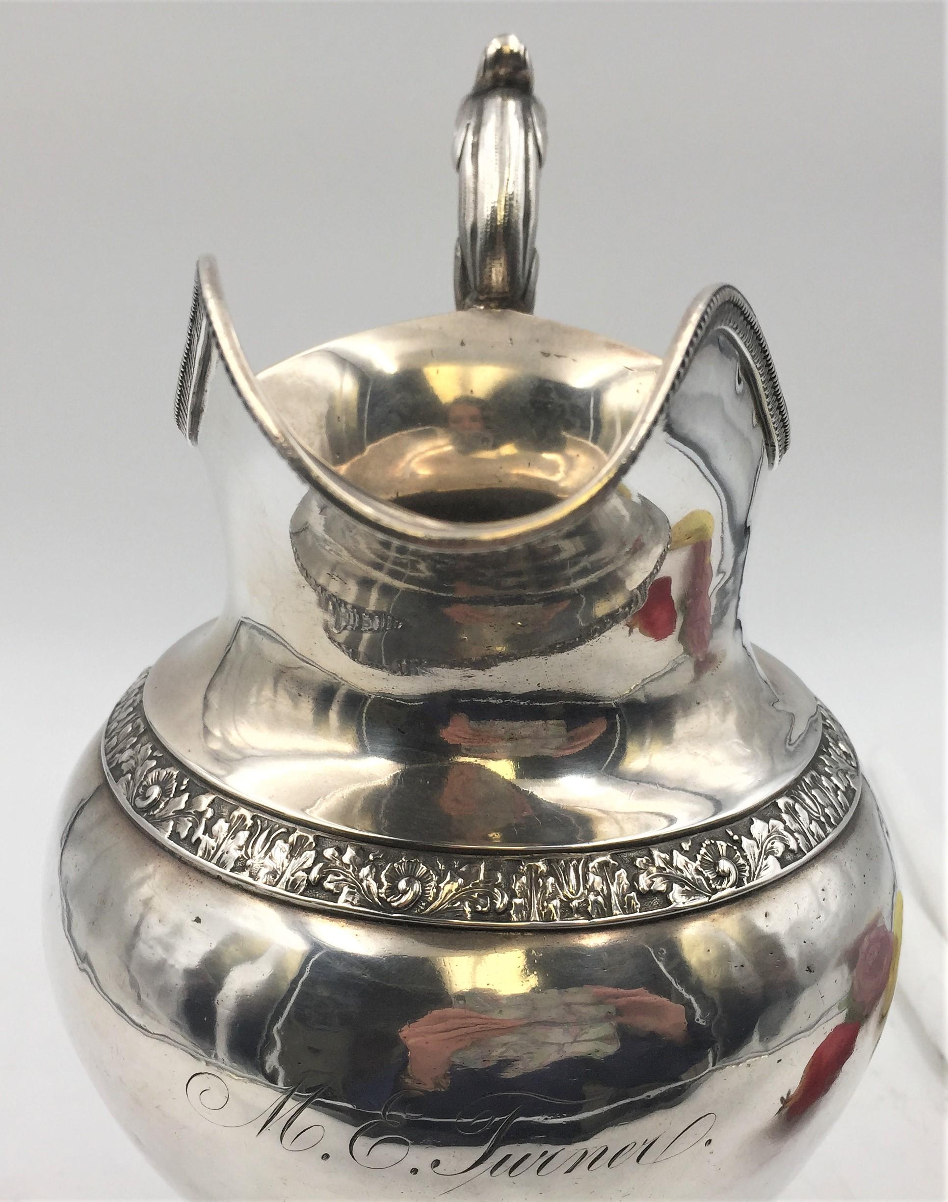 Coin silver hand hammered water pitcher circa 1850 by Philadelphia makers Bennett and Caldwell. Leaf motif along handle, leaf and floral design around body and base, intricate leaf and beading around rim of spout. Measuring 12 inches tall and 9 1/2