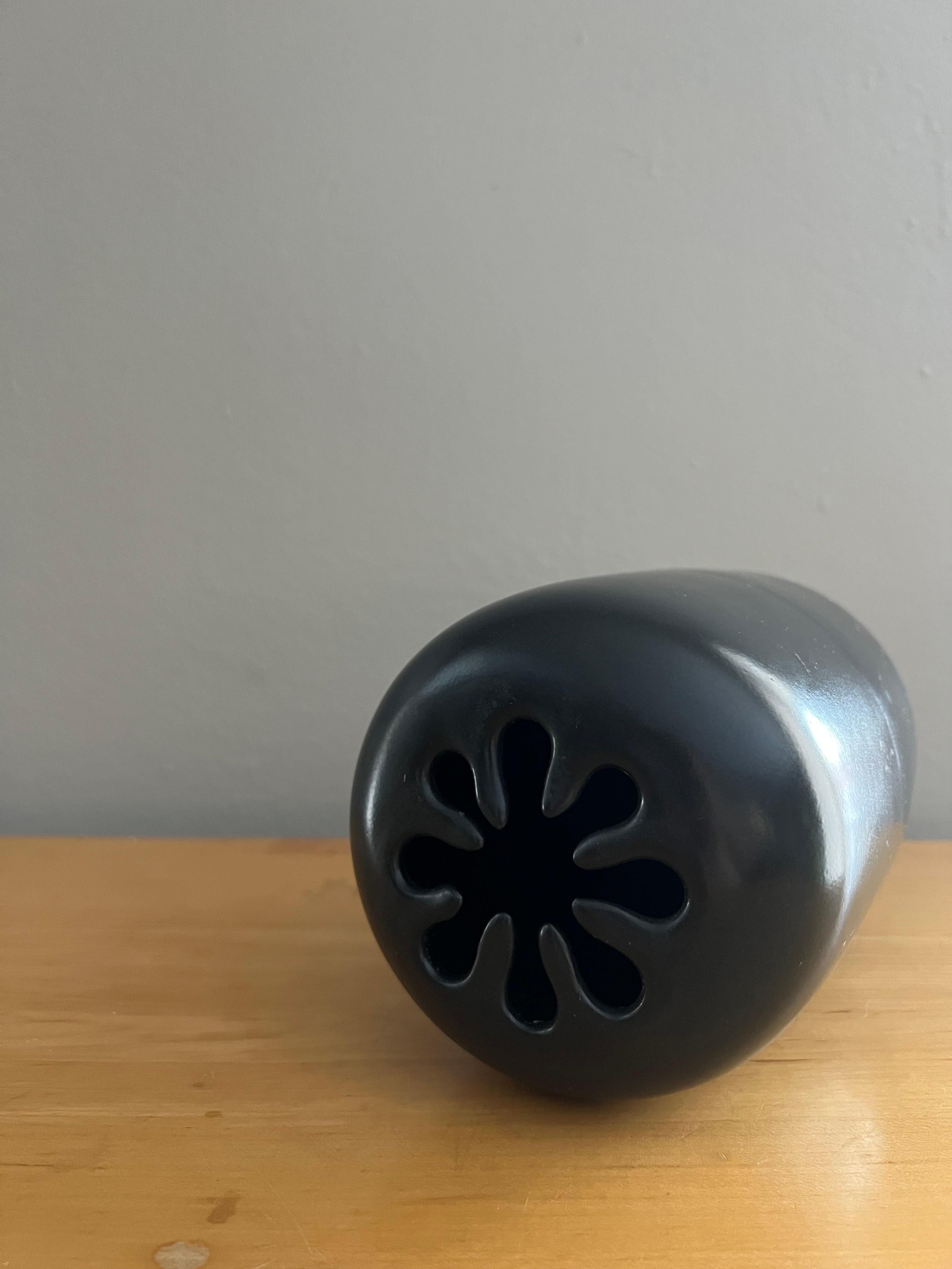 Two tone, black matte on black gloss spark vase by David Gil for Bennington Pottery.

Marked on the bottom. Difficult to capture as it isn't raised enough to be legible.