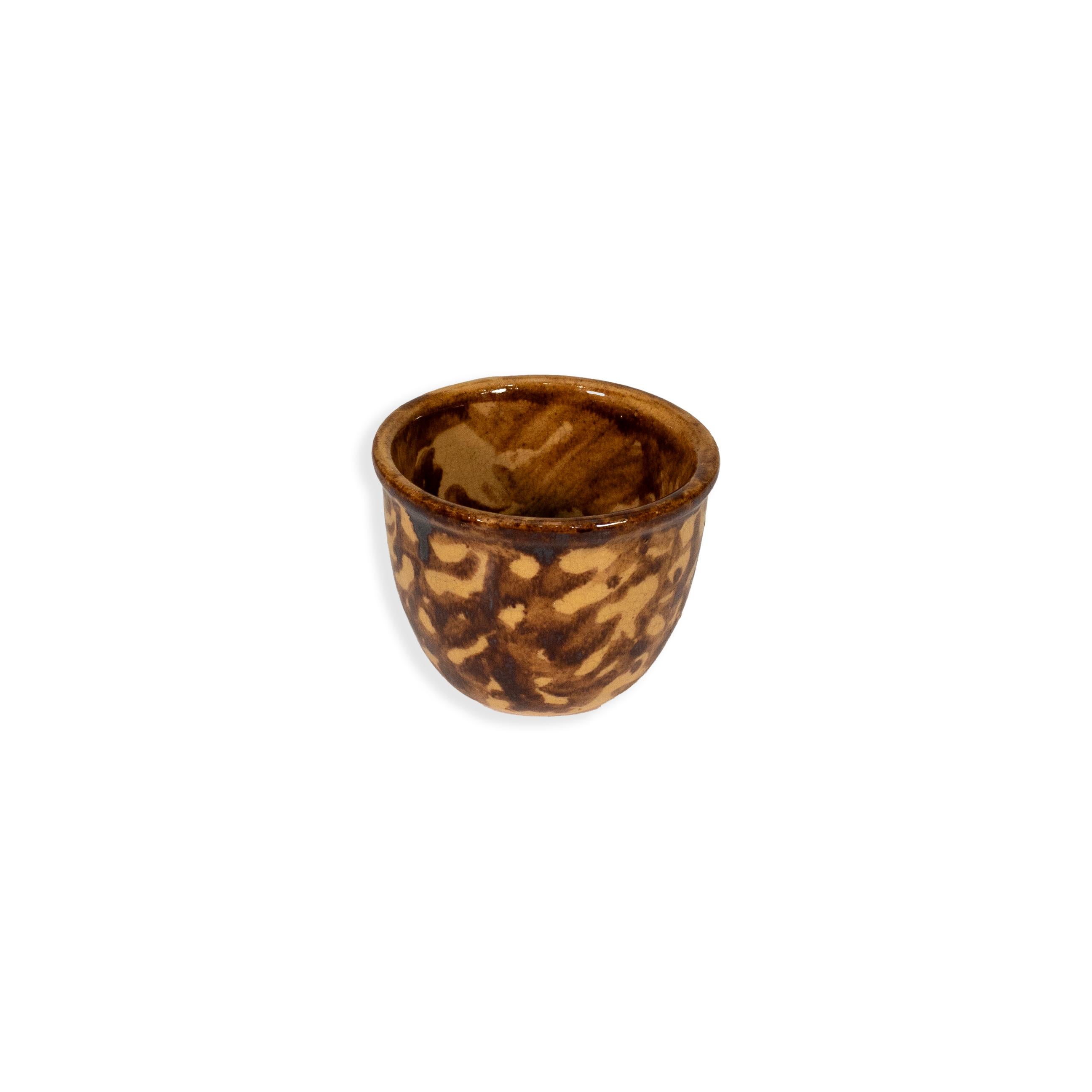 Un charmant assortiment de cinq bols vintage en poterie spongieuse, chacun d'entre eux étant émaillé à la main de façon unique dans une finition traditionnelle marbrée de brun et de tan. Cette collection présente une grande variété de tailles et de