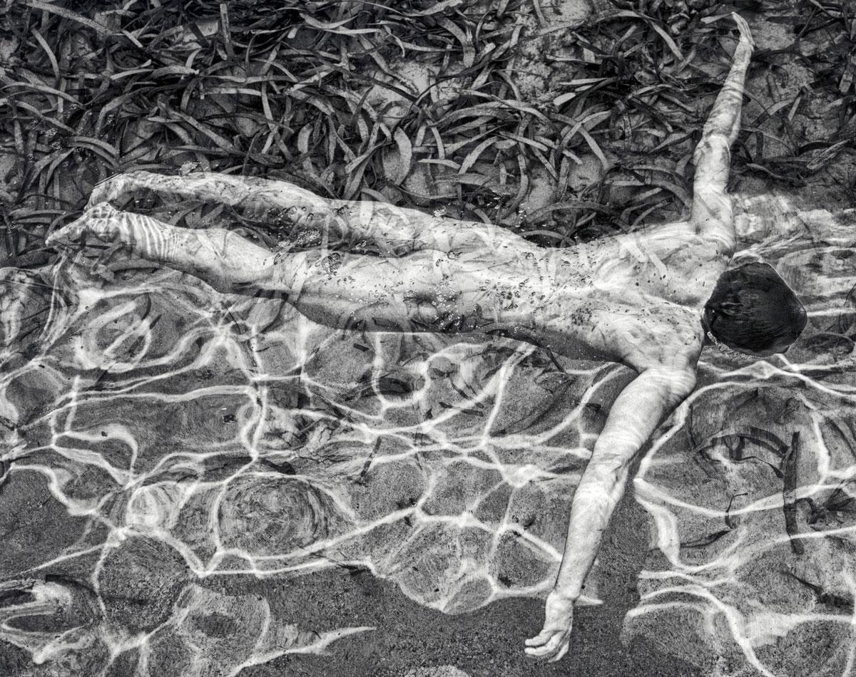 Swimming (Sensual nude male relaxes in the water  on a sunny day) - Photograph by Benno Thoma