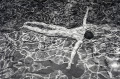 Swimming (Sensual nude male relaxes in the water on a sunny day)