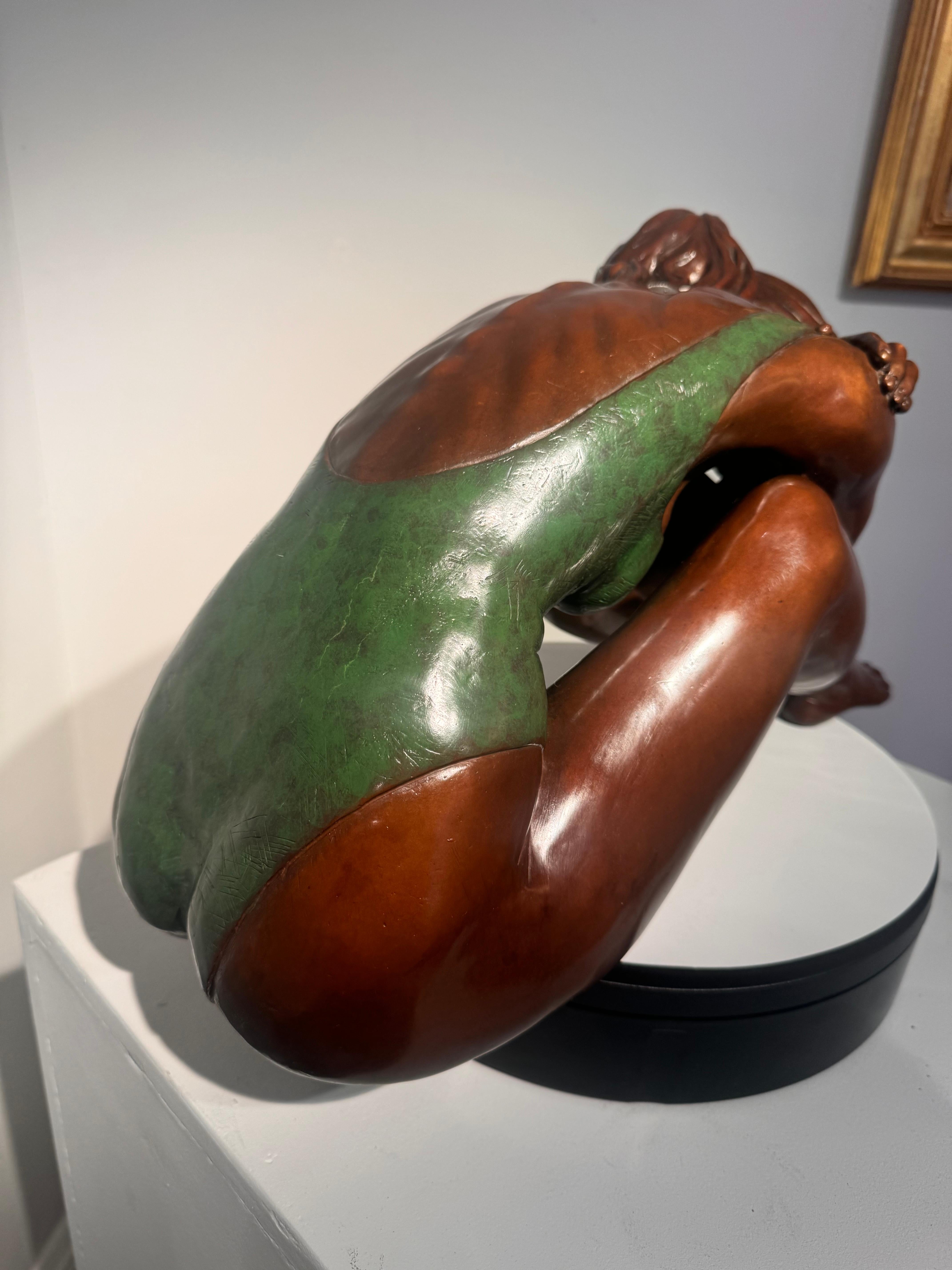Auflage von 25 Stück. Olympiade von Benson Landes. 
Die Bronzeskulptur einer Ballerina, die in einem Moment der Ruhe zusammengekauert ist, fängt sowohl Haltung als auch Introspektion ein. Der Bildhauer stellt die Tänzerin mit großer Sorgfalt in