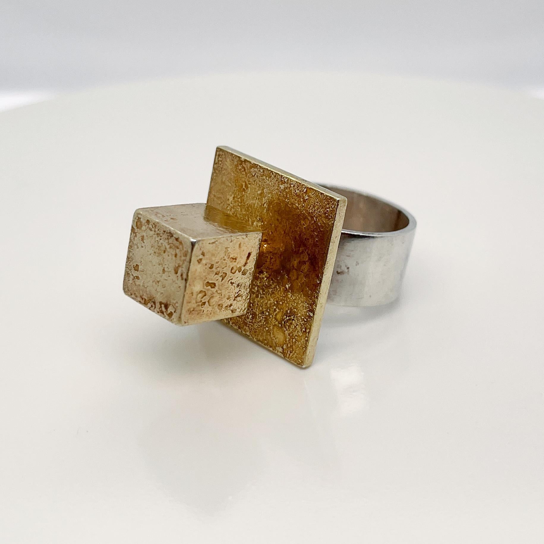 A very fine Bent Exner Danish modernist cocktail ring. 

The top with a fire-gilded cube set on a platform and supported by a thick sterling silver band.

Simply eye-catching design from an amazing jewelry maker!

Date:
20th Century

Overall