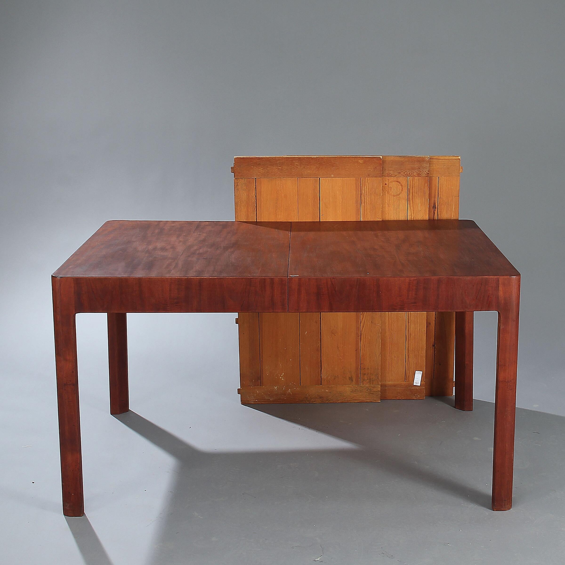 Rectangular dining table made of padouk wood with extension for three pine leaves (the pine leaves are of a different wood type and colour and assume a table cloth is used when extended). Made circa 1930s by cabinetmaker Jørgen Christensen. L.