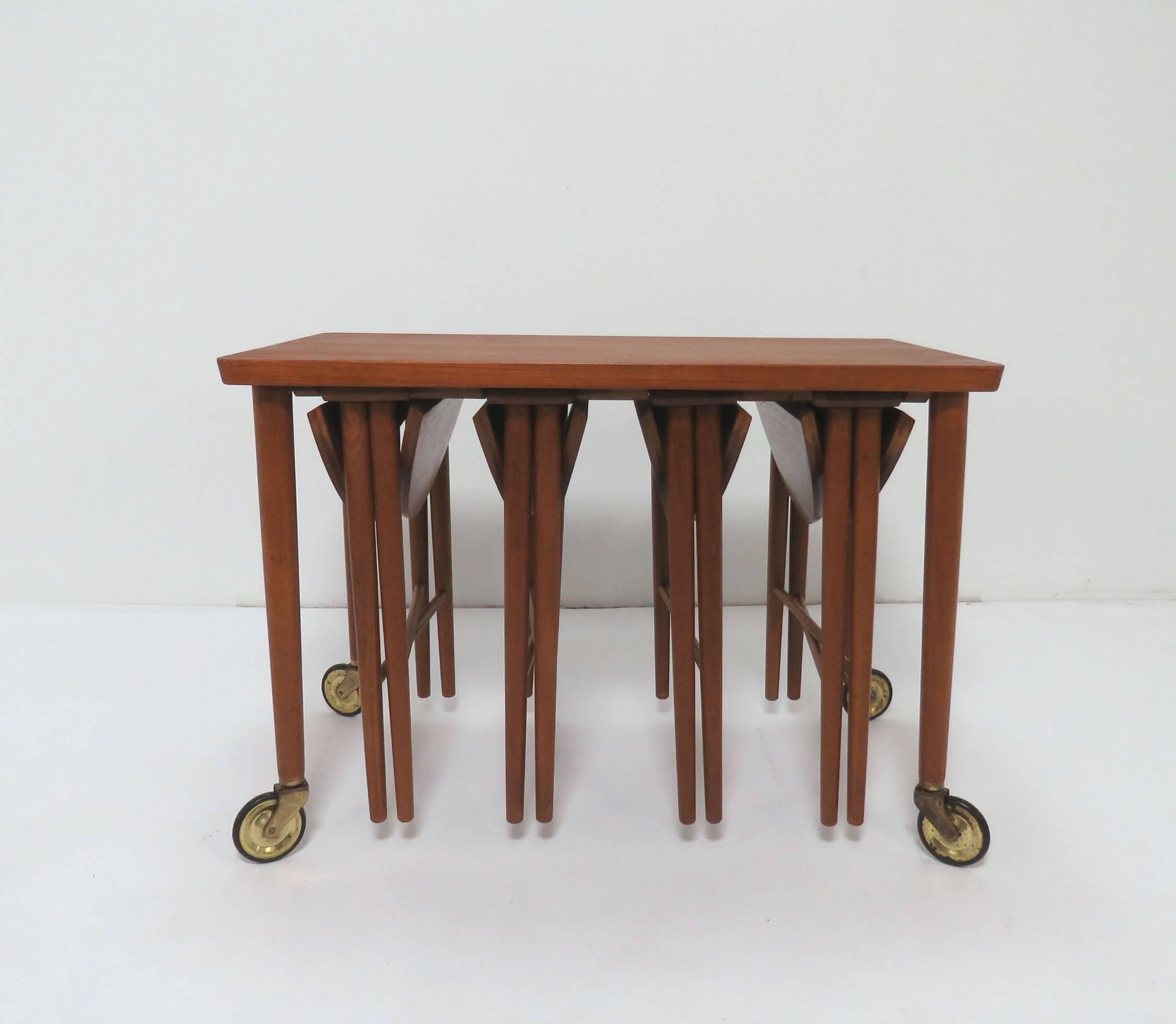 Set of Danish teak nesting tables, consisting of four folding tables that secure to the under side of a larger serving trolley on casters. By Bent Hundevad for Hundevad and Co., made in Denmark, circa 1960s.

The folding tables measure 15 1/8