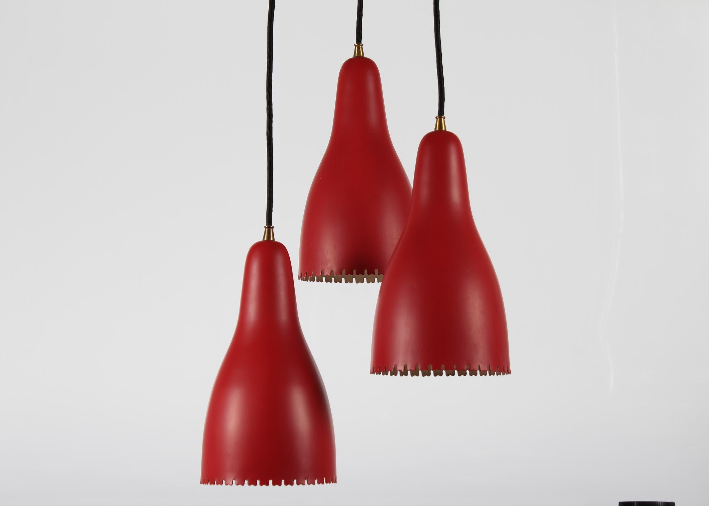3-Cone chandelier designed by Bent Karlby for Lyfa Denmark

The metal shades are with red lacquer outside and white inside.
The chandelier has brass fittings and canopy

Measures: height: The length of the cord is adjustable 108 cm + 42 cm.