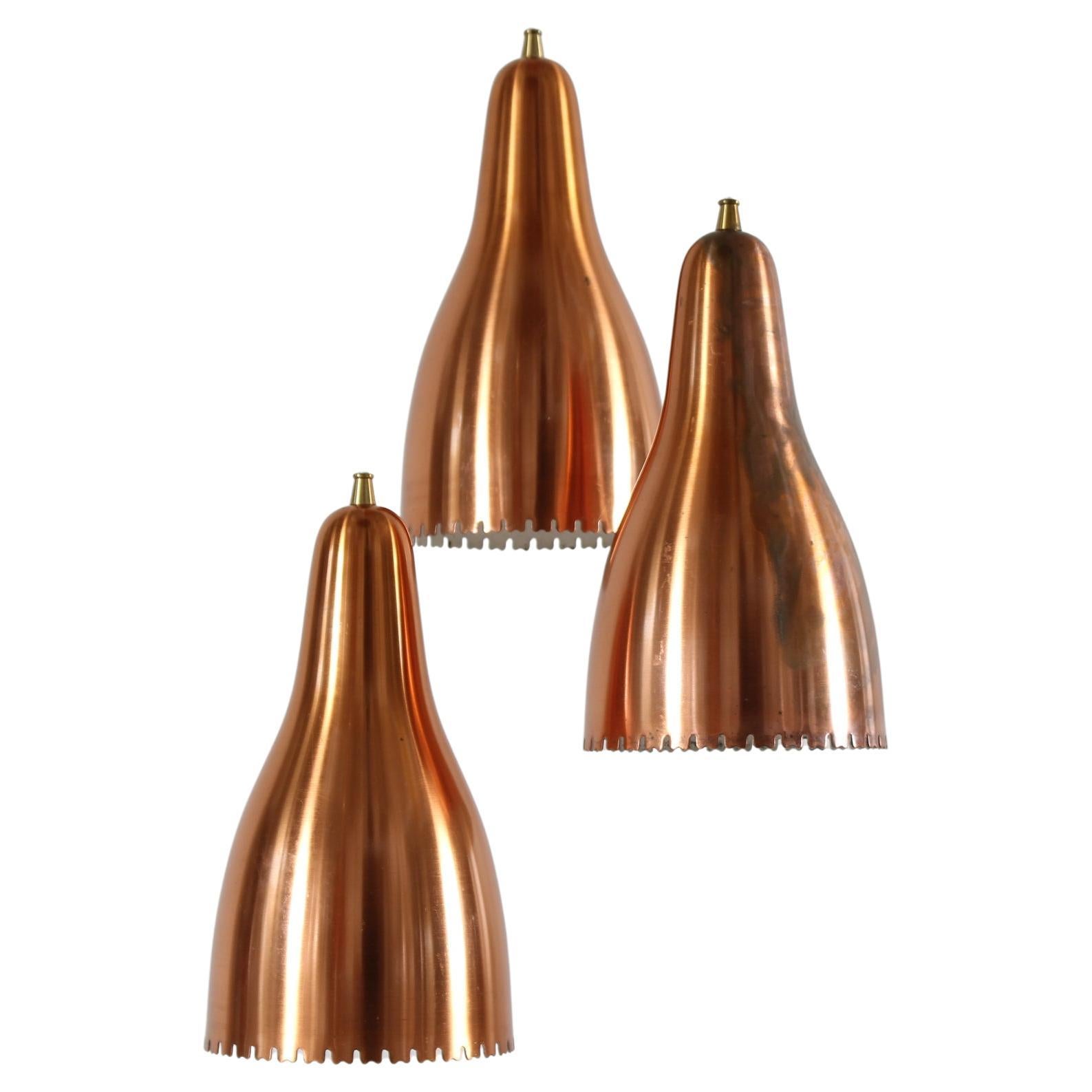 3-Cone chandelier with canopy designed by Bent Karlby for Lyfa Denmark in the 1960s

The cobber shades  are covered with white lacquer inside to to promote the light reflection downwards.
On the top of the shades are mountes small brass fittings for