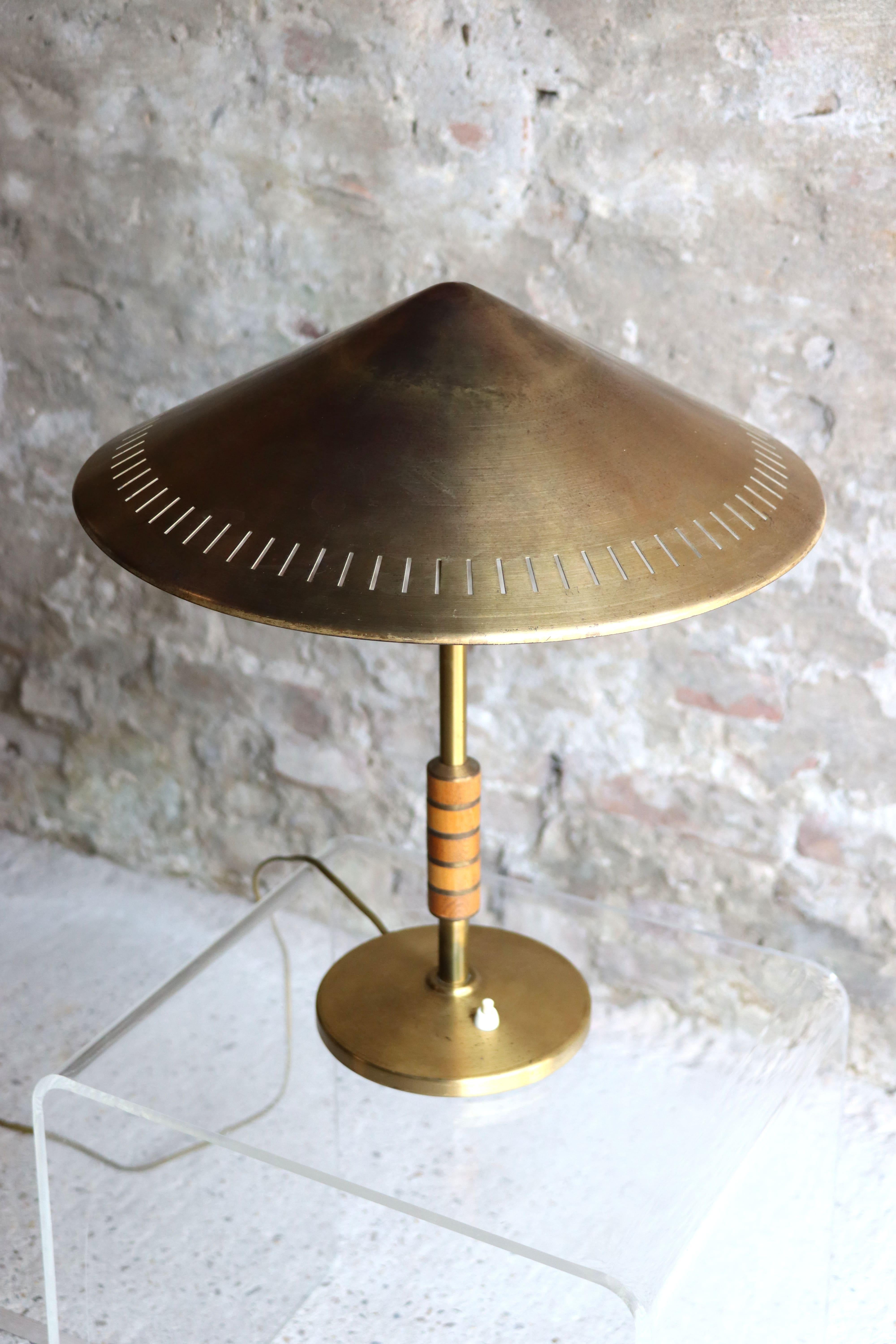 This beautiful Danish table lamp in solid brass with mahogany handle is designed by Bent Karlby in 1956. It is manufactured by LYFA, Copenhagen. This lamp is ultra rare and only a handful came on the market. It has a beautiful patina and marks of