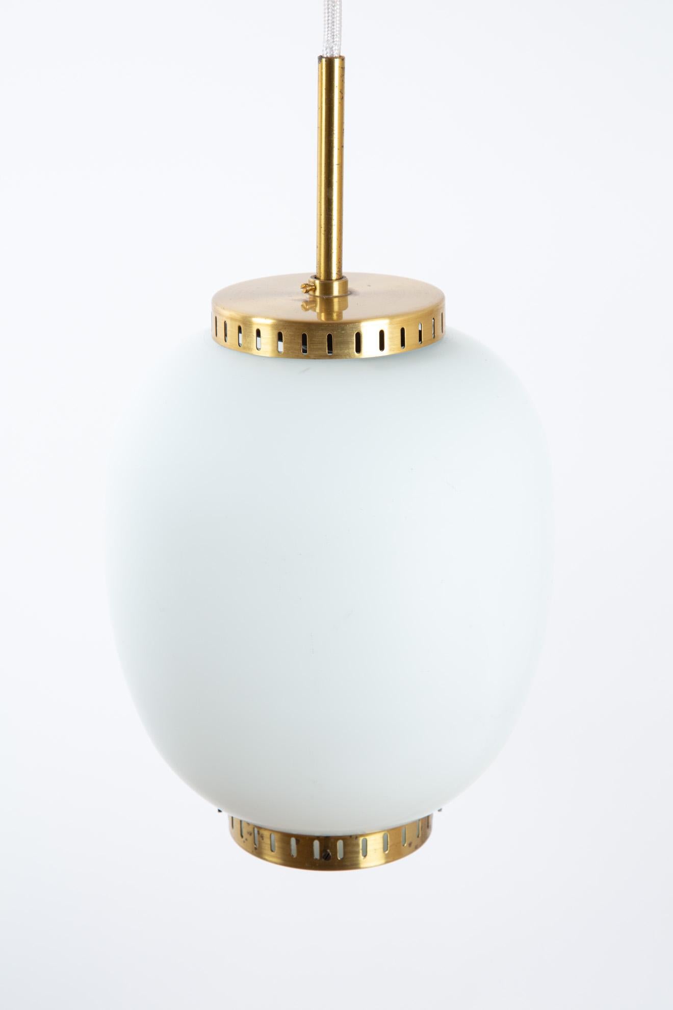 Bent Karlby Scandinavian Modern pendant lamp. The lamp has the form of a Japonese lampion light. A perfect form. The top and bottom are of gold brass. Price a piece, there are two in stock.