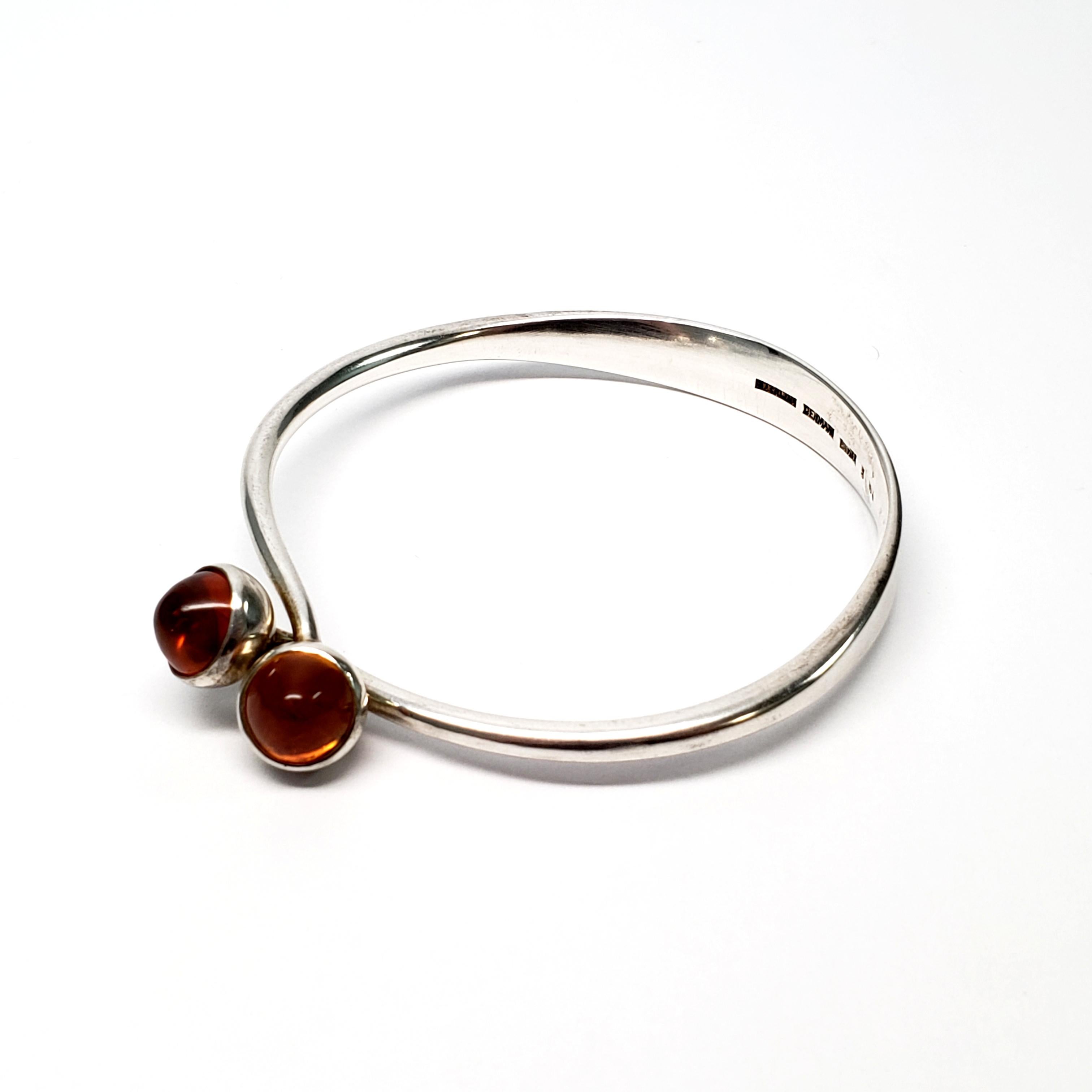 Vintage Bent Knudsen sterling silver and amber cabochon bangle bracelet.

Interlocking sterling silver bangle bracelet, by Bent Knudsen of Denmark, featuring 2 round, high set amber cabochons. Circa 1956.

Size: measures 7 3/4