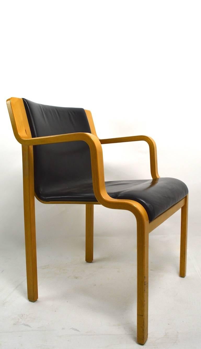 Bent laminated wood arm chair by Stendig. Unusual to find this model in leather upholstery. Chic architectural style, with sophisticated Northern European design. Measures: Seat H 17, arm H 25.