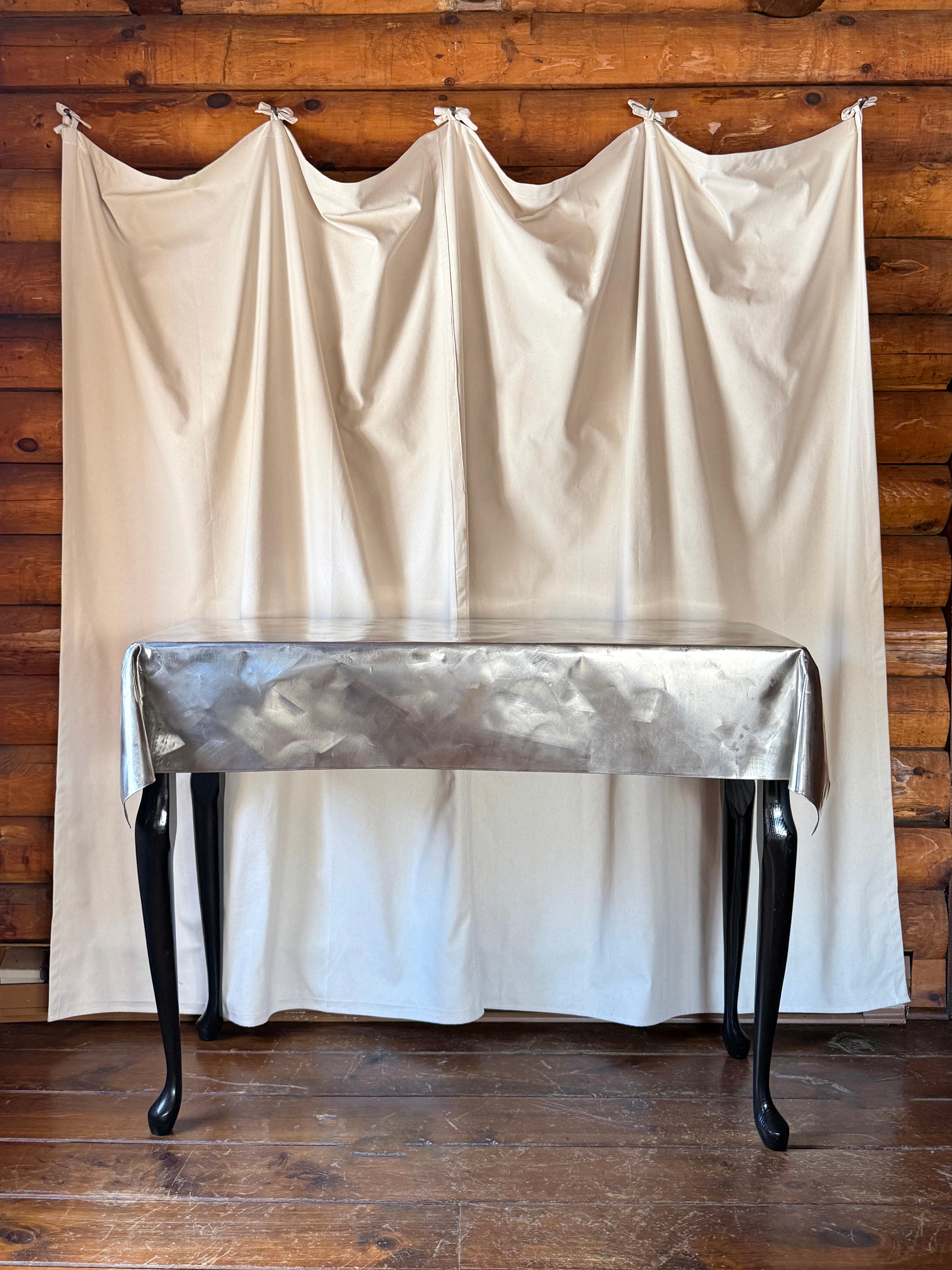 Table en métal courbé avec pieds en bois dans le style de John Dickinson

Une table console unique et originale fabriquée en bois massif et en tôle pliée. La tôle a été façonnée de manière experte pour imiter l'aspect d'une nappe en tissu. Bien que