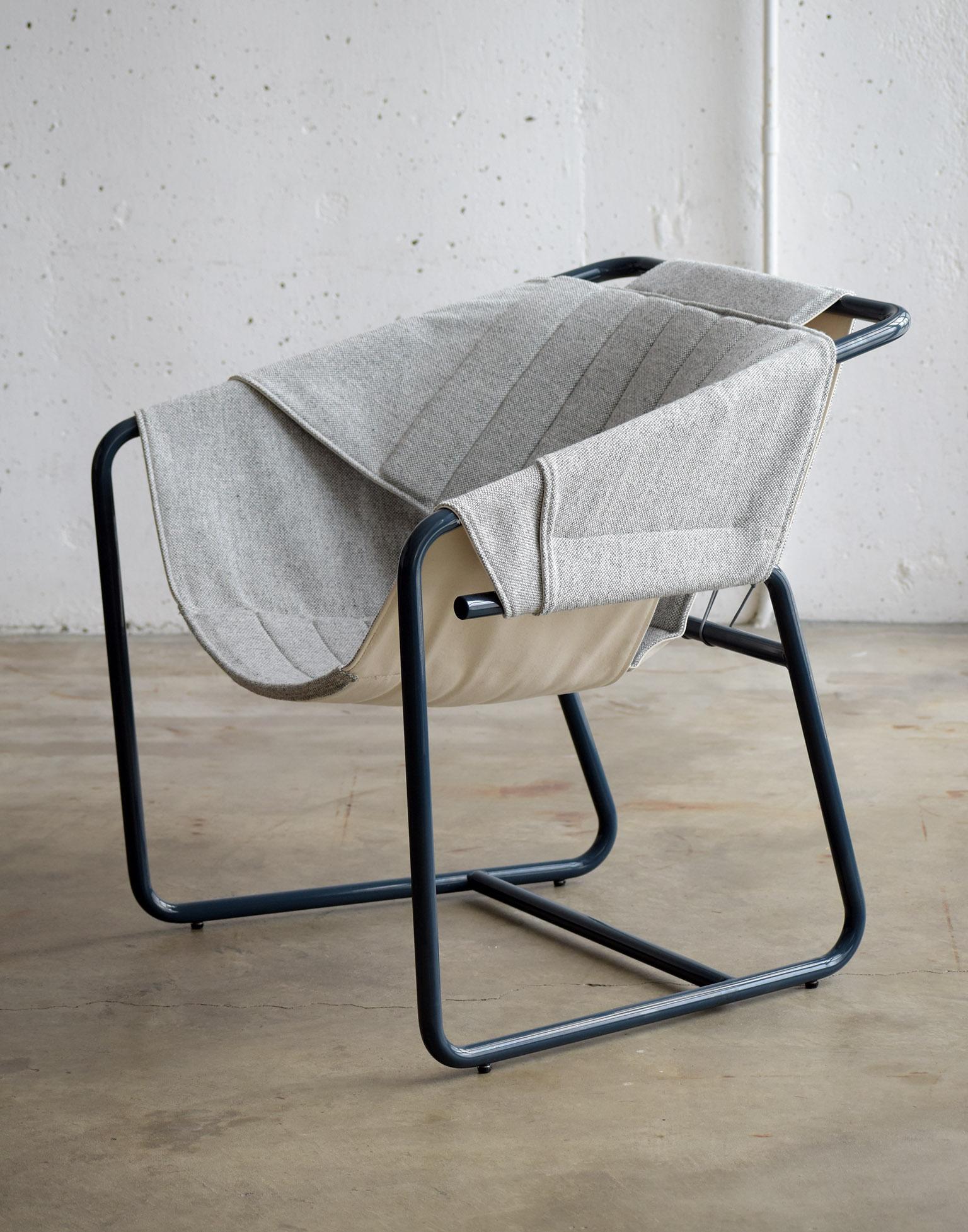 The easy chair combines the casual vibe of sling chairs with the cozy comfort of a classic club chair all in a floating form reminiscent of midcentury shell chairs. The top layer of the quilted sling is available in a choice of upholstery fabrics