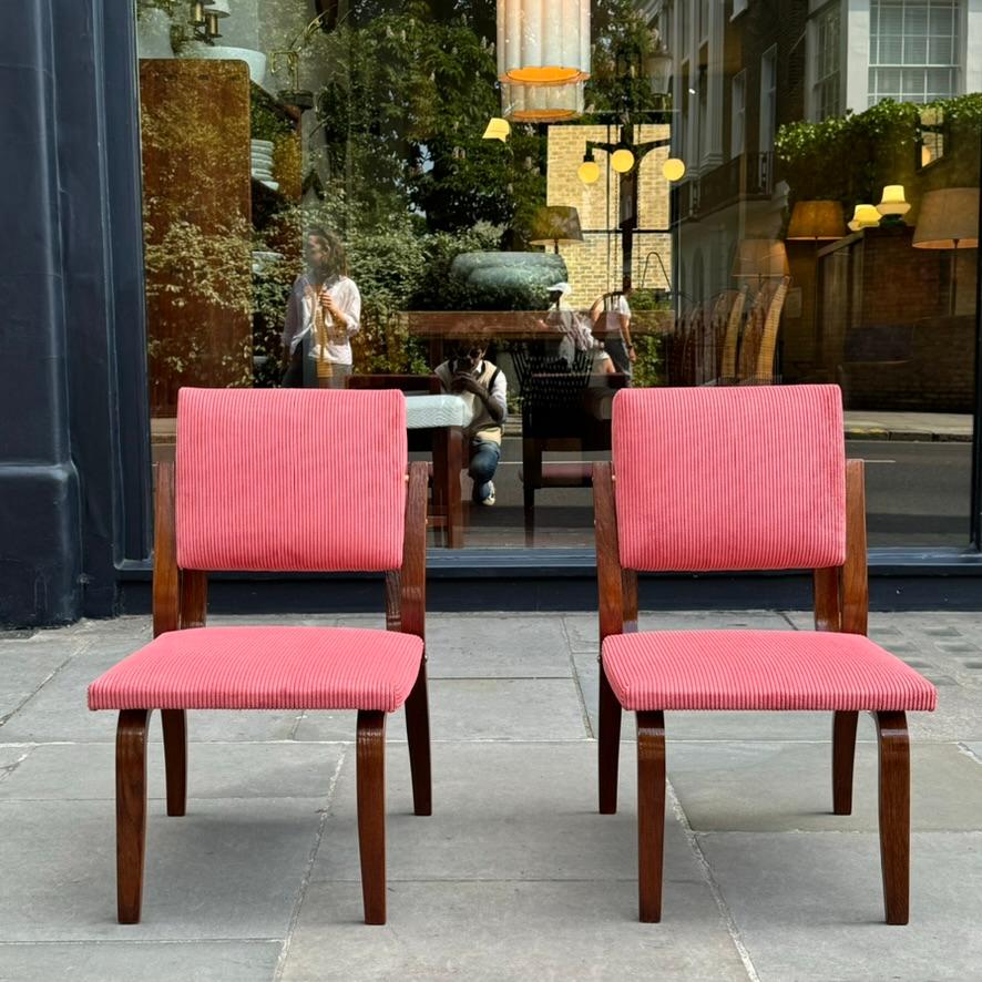 Paire de chaises en bois courbé, en chêne foncé, garnies d'un tissu en corderoy rose, fabriquées par Dřevopodnik Holešov dans les années 1970, une entreprise de meubles basée dans l'ancienne Tchécoslovaquie qui poursuit ses activités à ce jour.

Les