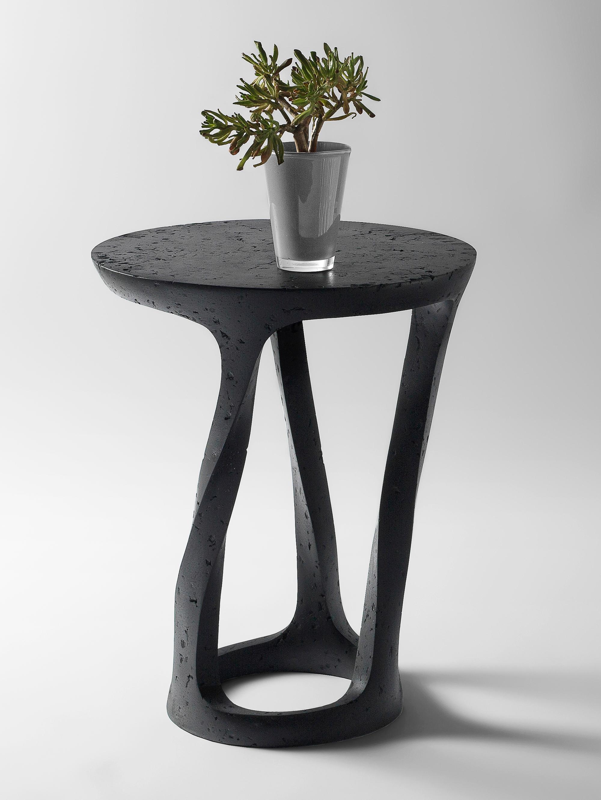 Bent Side Table by Kasanai
Dimensions: D 45 x H 62 cm.
Materials: Cement, wood, recycled paper, glue, paint.
6 kg.

The fusion of sturdiness and elegance, along with the blend of archaism and modernity. More than just a surface for placing objects,