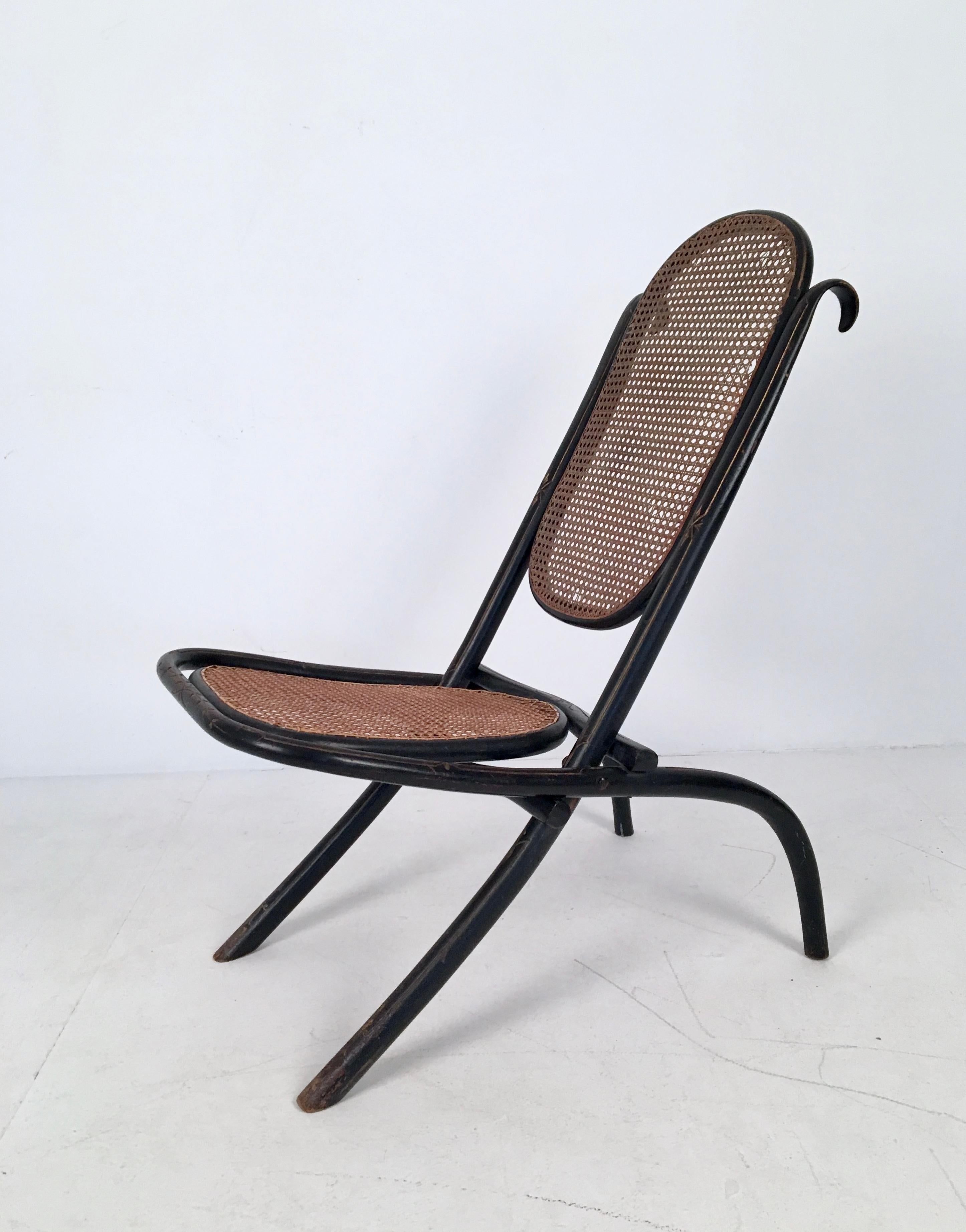 Rare folding cane chair from the aesthetic movement, produced by Thonet, c.1860.

In fair condition, with minor scuffs to the frame and a small areas of loss to the cane.

Dimensions (cm, approx): 
Height: 75 
Width: 45 
Depth: 50.