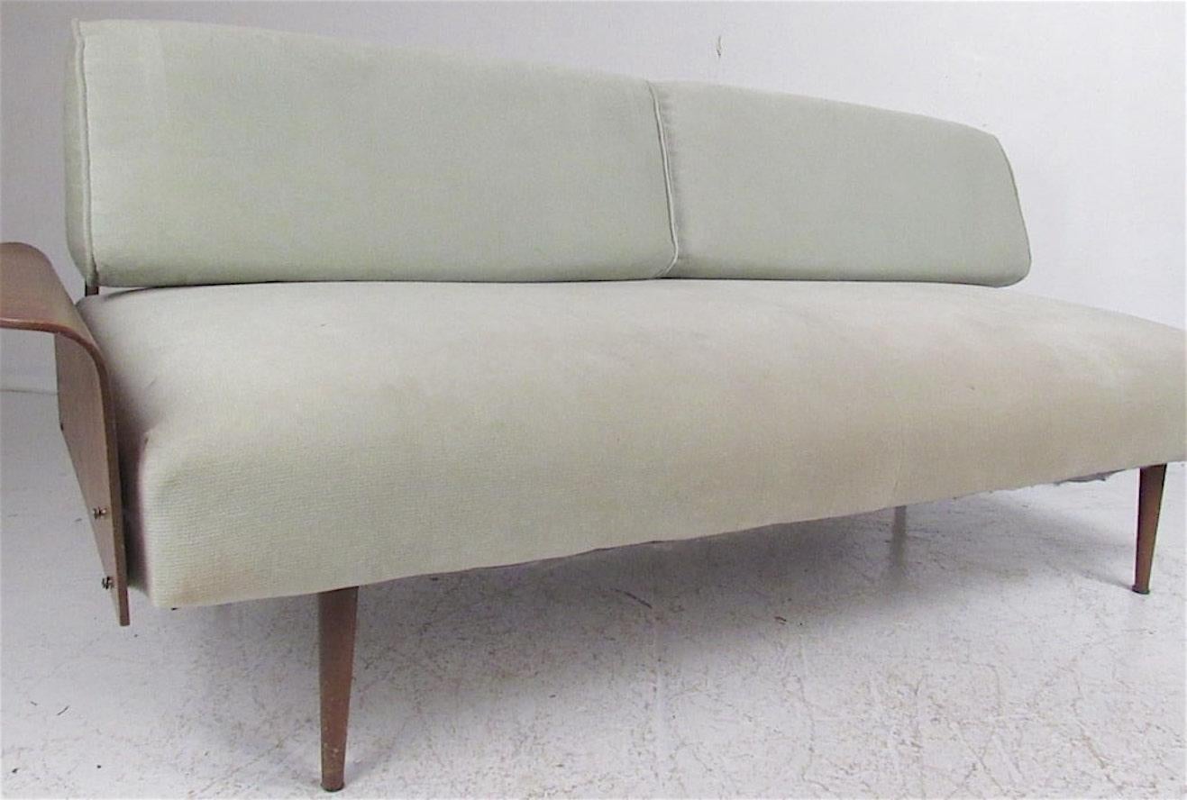 Great mid-century vintage sofa/daybed with single bent plywood fan arm and tubular metal backrests. 
* Two are available with arms on either side. Please confirm which side you prefer.
Please confirm item location (NY or NJ) with dealer.