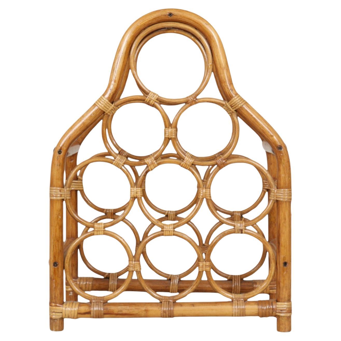 A bentwood bamboo and rattan wine rack, designed to hold nine bottles of wine. Joints and pencil wood bamboo circles are secured with rattan wrapping. The circles are stacked three over six.