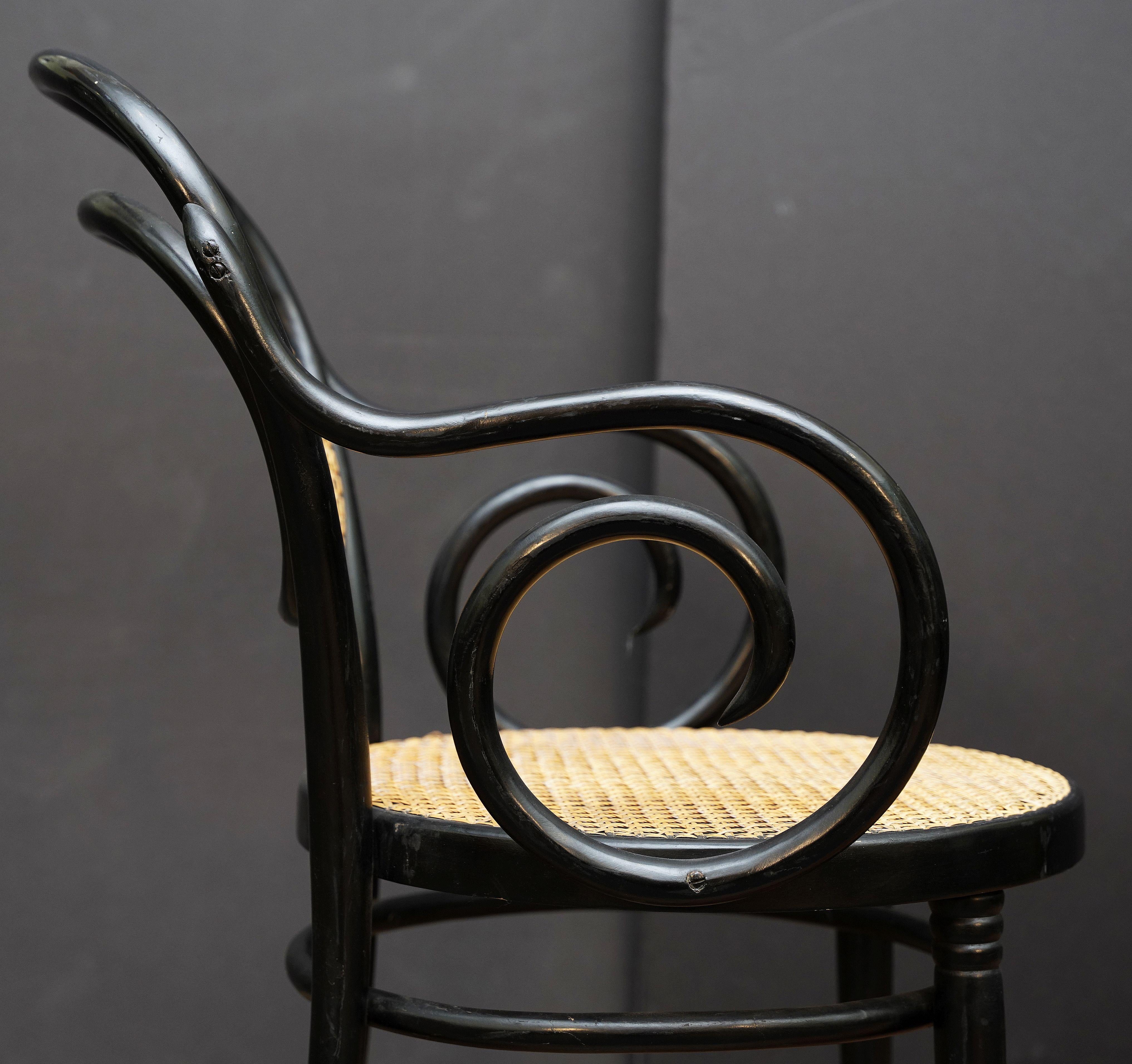 20ième siècle Fauteuil en bois courbé noir avec assise et dossier cannés d'Italie (Deux Disponibles) en vente