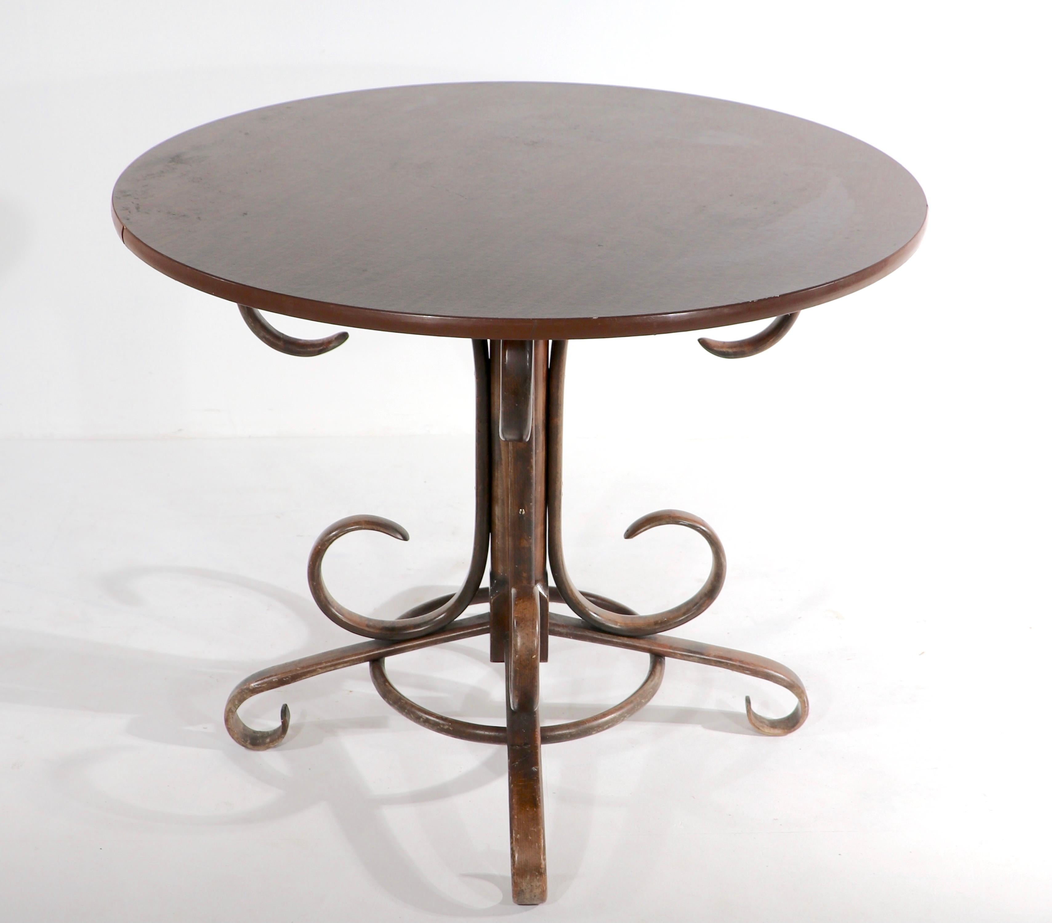 Chic voguish Vienna Secessionist style cafe dining table made in Italy circa 1970’s. Steam bent wood base, faux wood formica top. It’s medium scale makes this table easy to place and totally functional. This listing includes the cafe table only, not