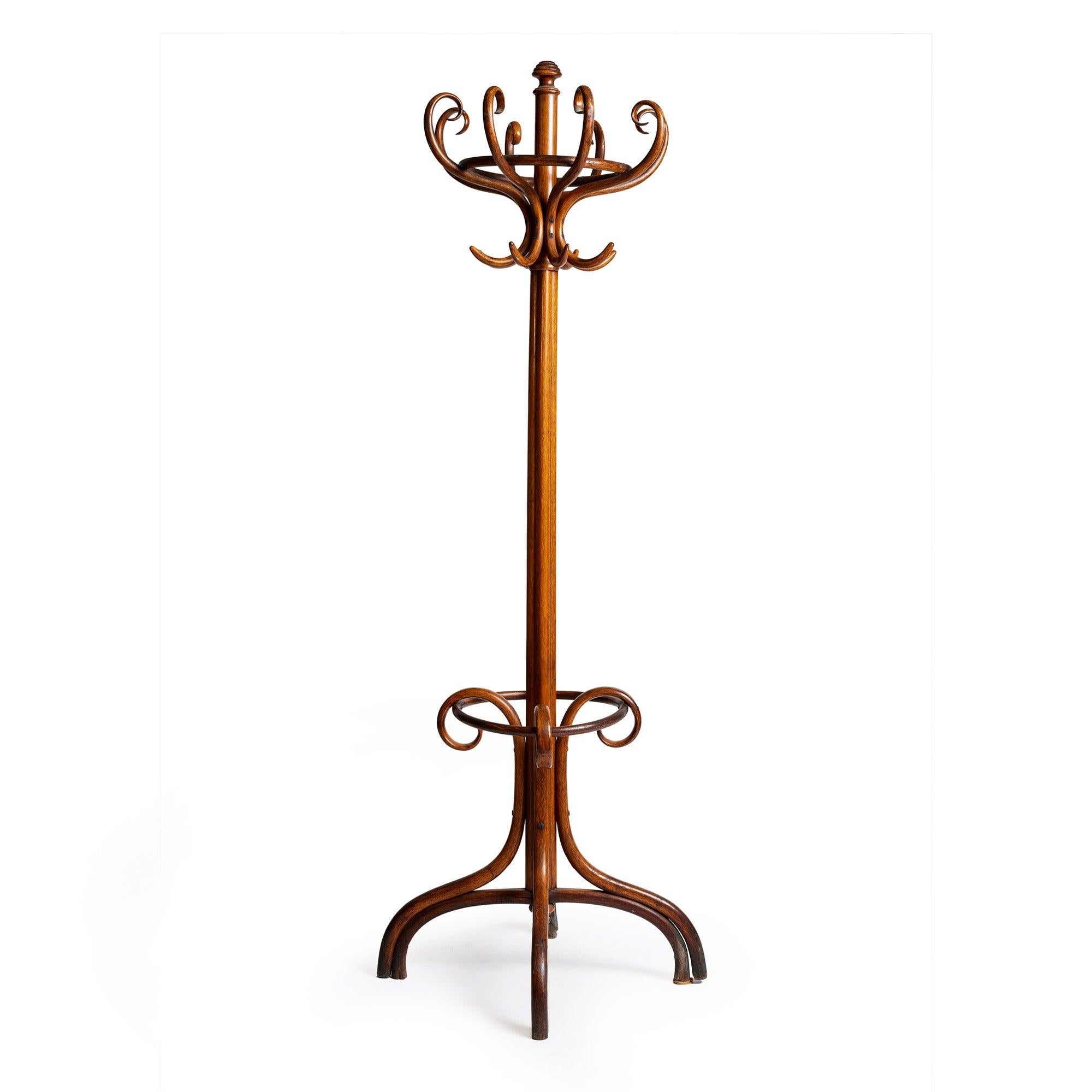 Un albero per cappotti in legno curvato con otto ganci doppi per cappotti e cappelli e un portaombrelli.