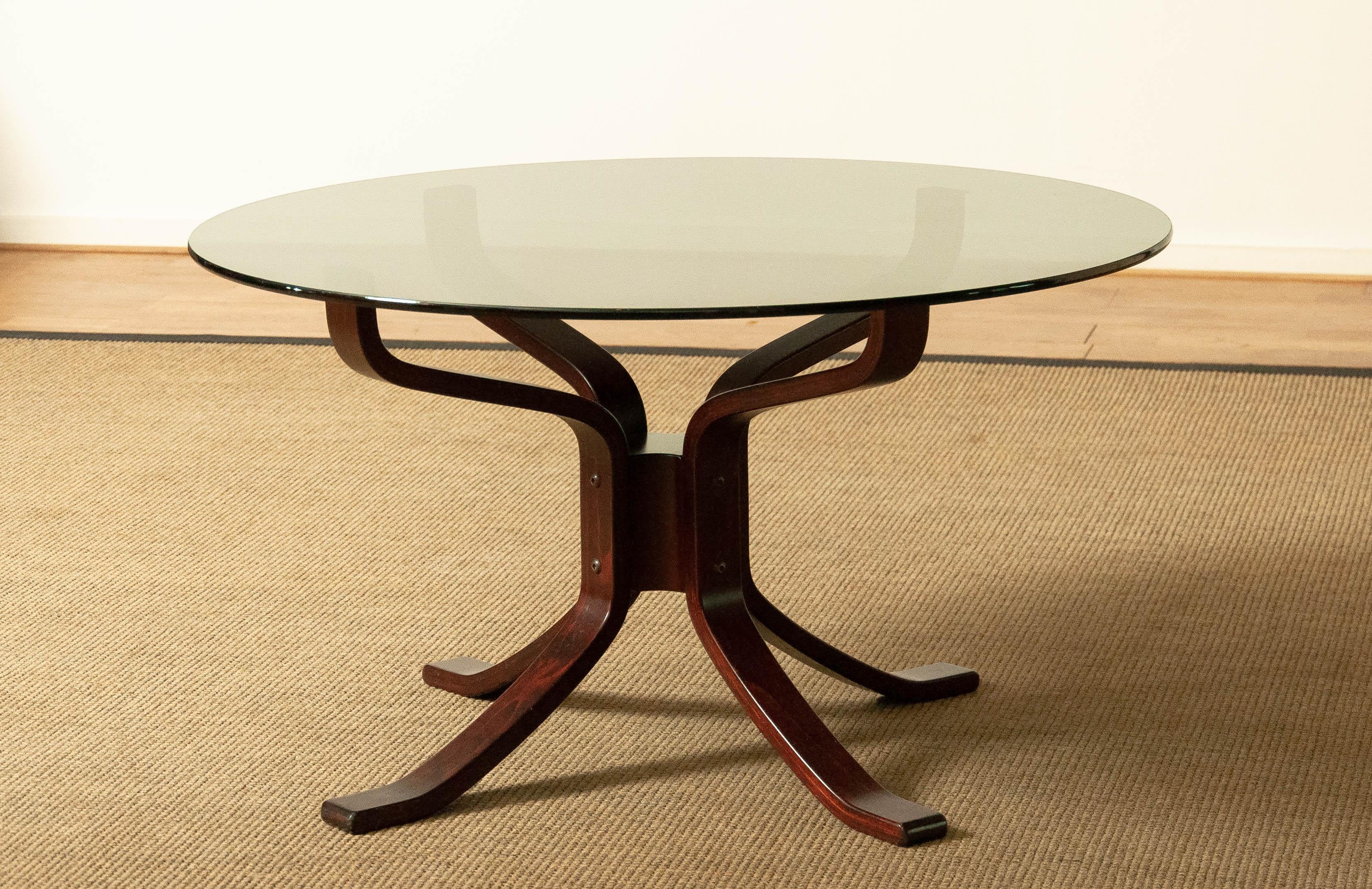 In very good condition coffee table made of bentwood frame. Unique to this model is the wooden connection centered between the four legs what give this coffee table a higher standart then the regular used metal tube. The smoked top is ø 90 cm