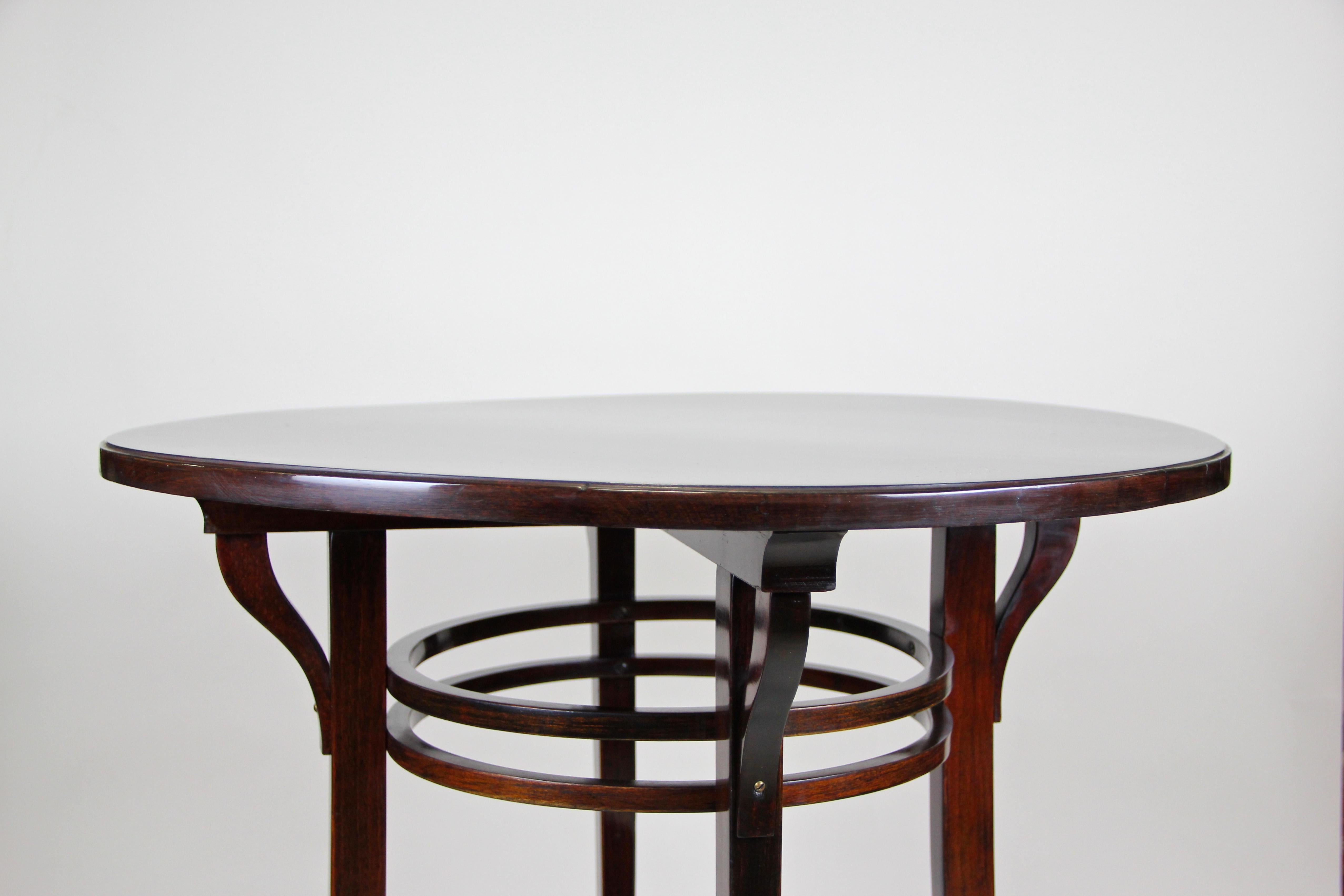 Timeless bentwood side table by the famous company of Thonet Vienna/ Austria from the early 20th century, circa 1905. The round table comes with a great design and shows an extra small floating compartment in the lower third. The table top is