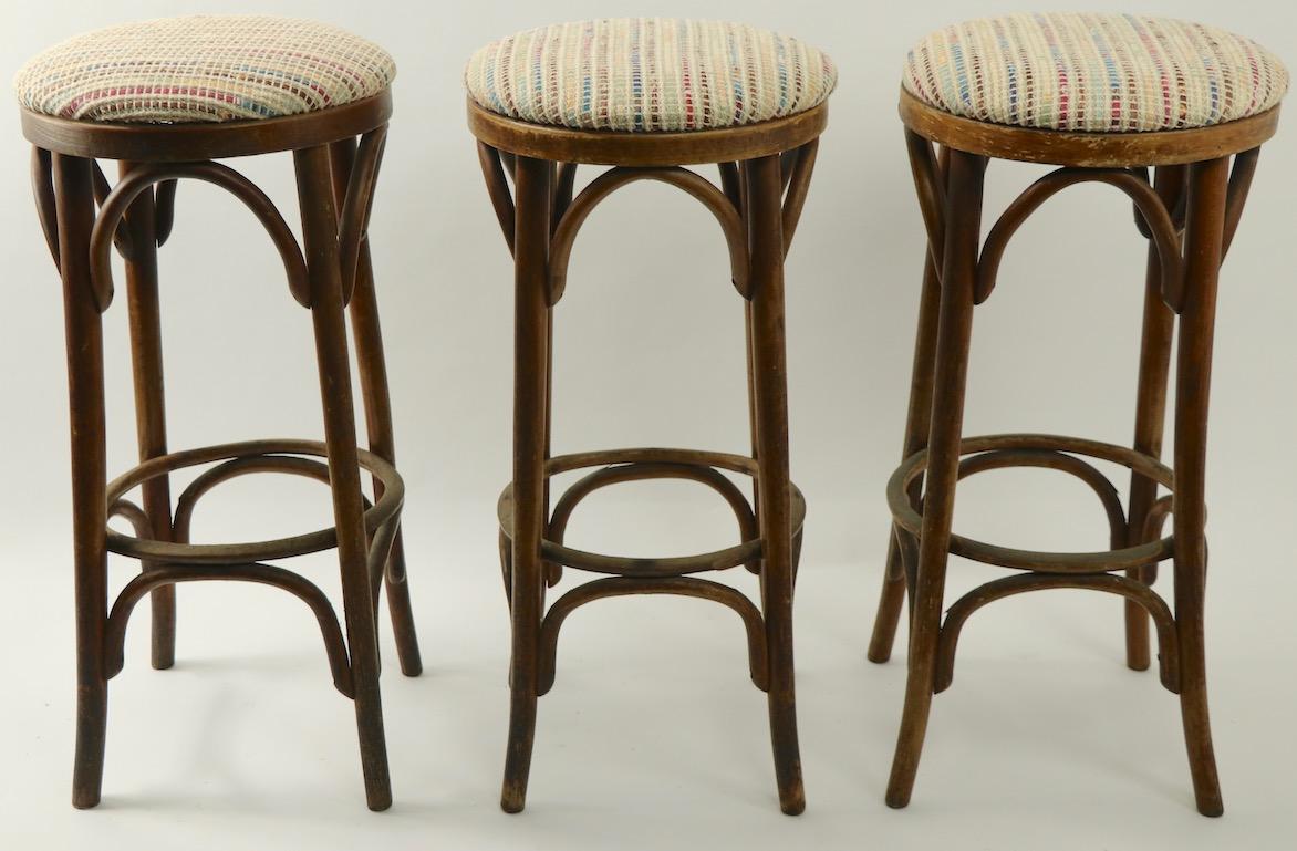 Nice group of 3 bentwood stools, attributed to Thonet.
Each stool has been recently reupholstered in earth tone woven fabric, structurally sound and solid, cosmetic wear to wood finish, normal and consistent with age.
Offered and priced