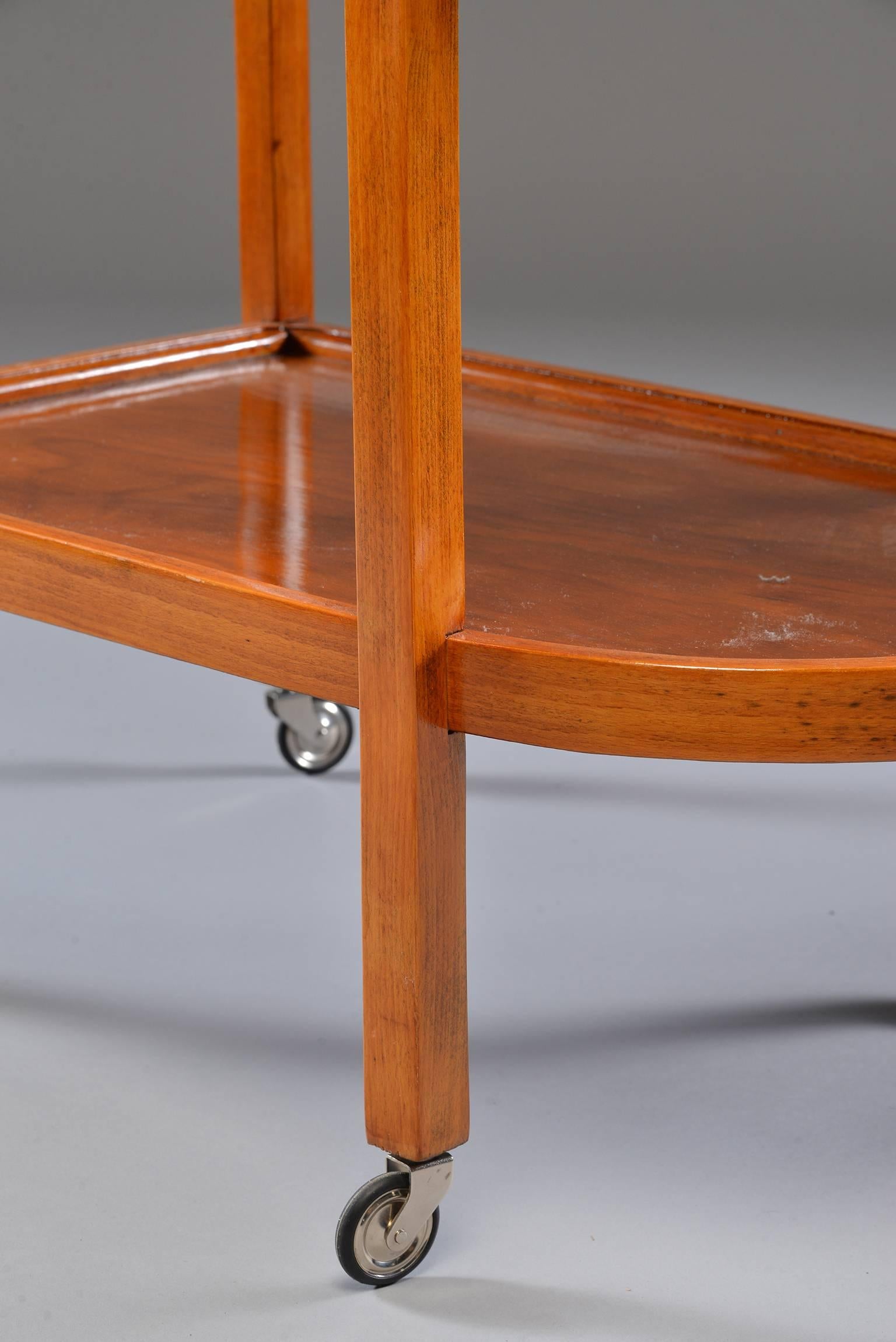 Two-tier trolley or tea cart has bentwood frame with rounded fronts. Elegant bentwood handle and all four legs have functional casters, circa 1930s. Unknown maker. Found in Italy.