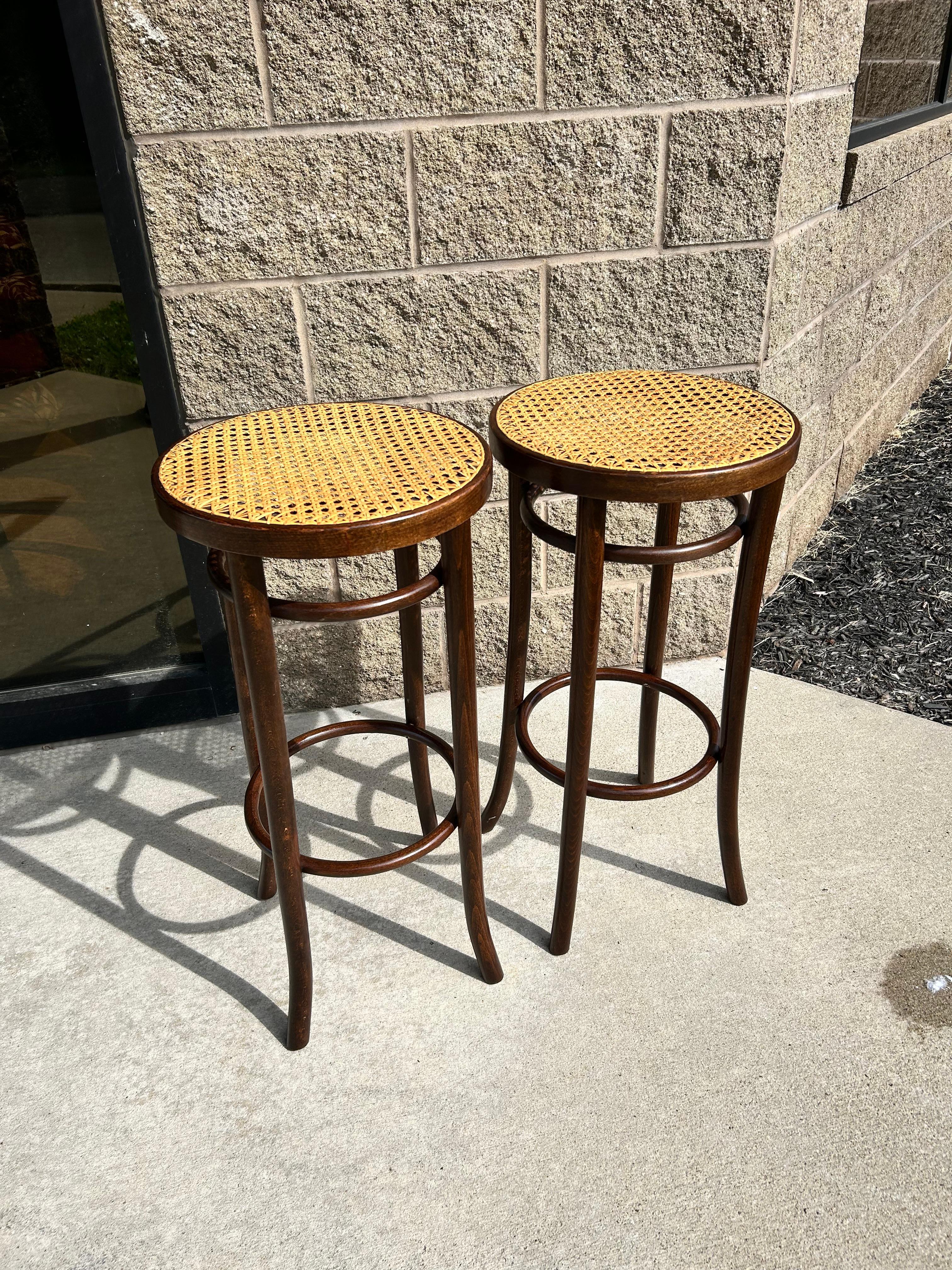 Paire de tabourets de bar en bois courbé et en paille de Vienne de style Art Nouveau, magnifiquement conservés.  Les tabourets de bar sont construits en bois de hêtre courbé teinté dans un riche noyer, et comprennent l'assise originale en paille de