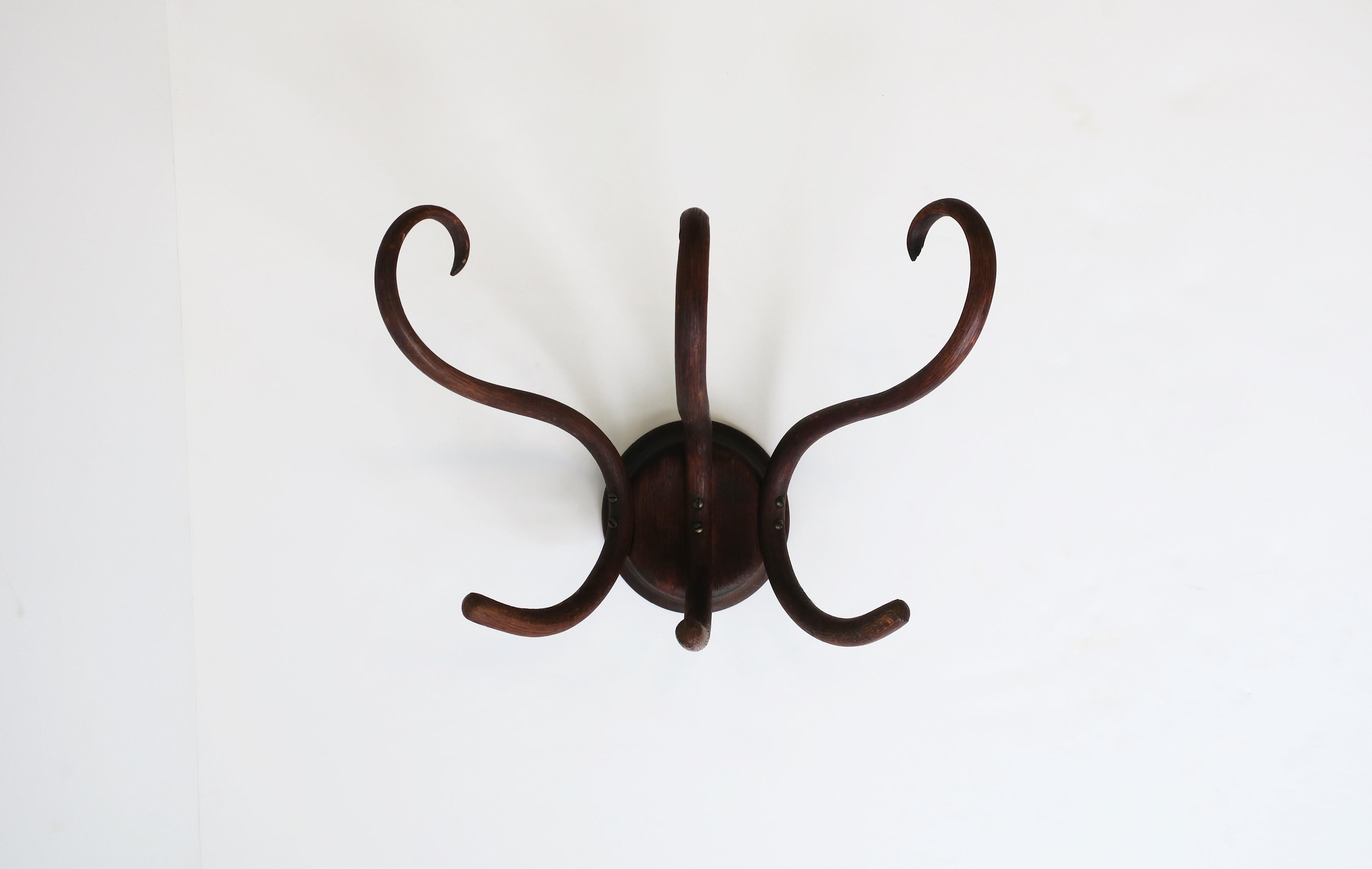 A beautiful vintage bentwood wall hall coat rack in the style of Thonet, circa early to mid-20th century. This wall coat rack has three hooks at top and three at bottom, so 6 hooks in total to hold coats, jackets, hats, umbrellas, etc. Piece is