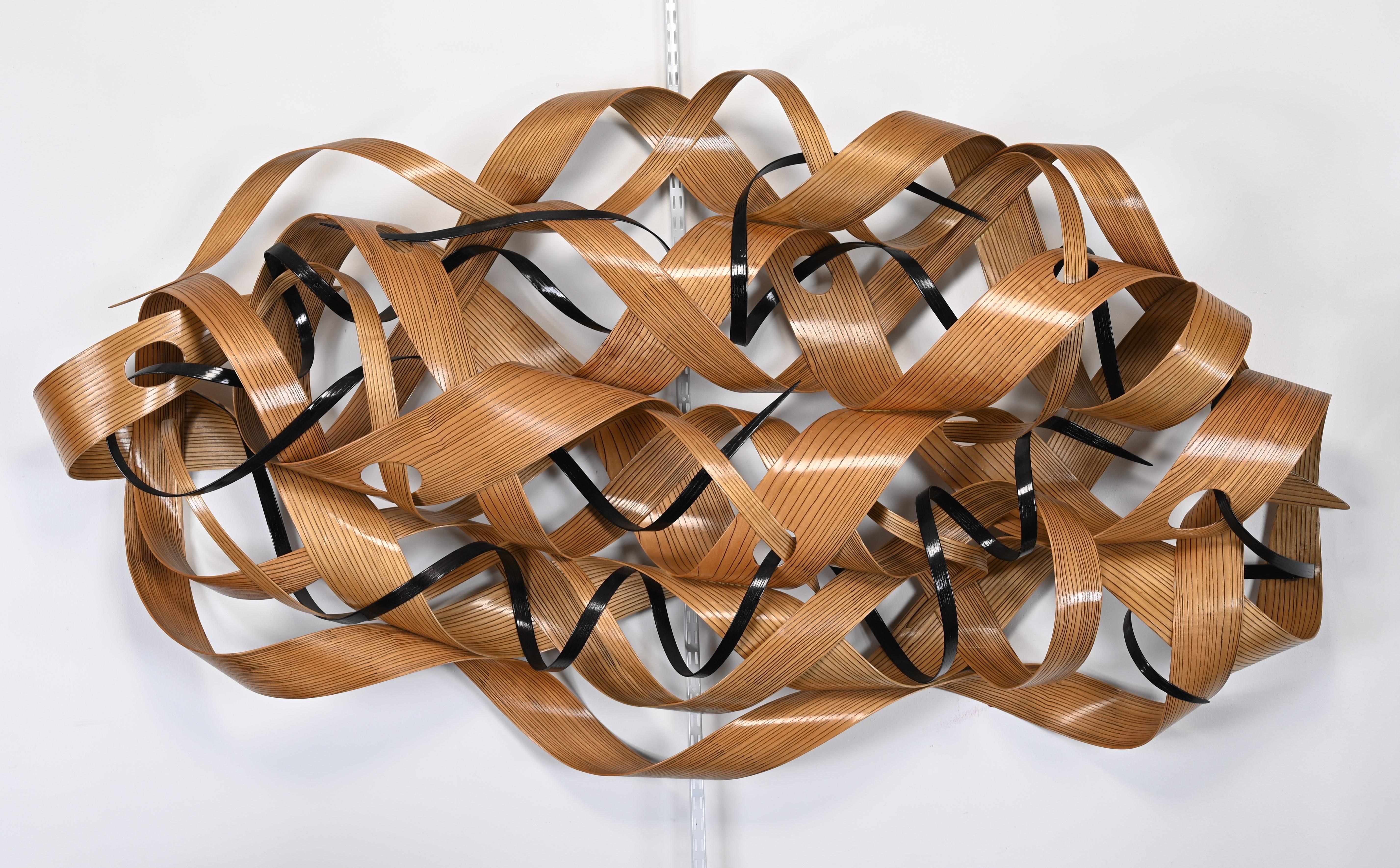A unique freeform steam-bent wall sculpture made of oak by Renee Dinauer. Her love for constructionism as sculpture and architecture is her inspiration for this unique wall sculpture. Her work is displayed in hotels, corporations, and private