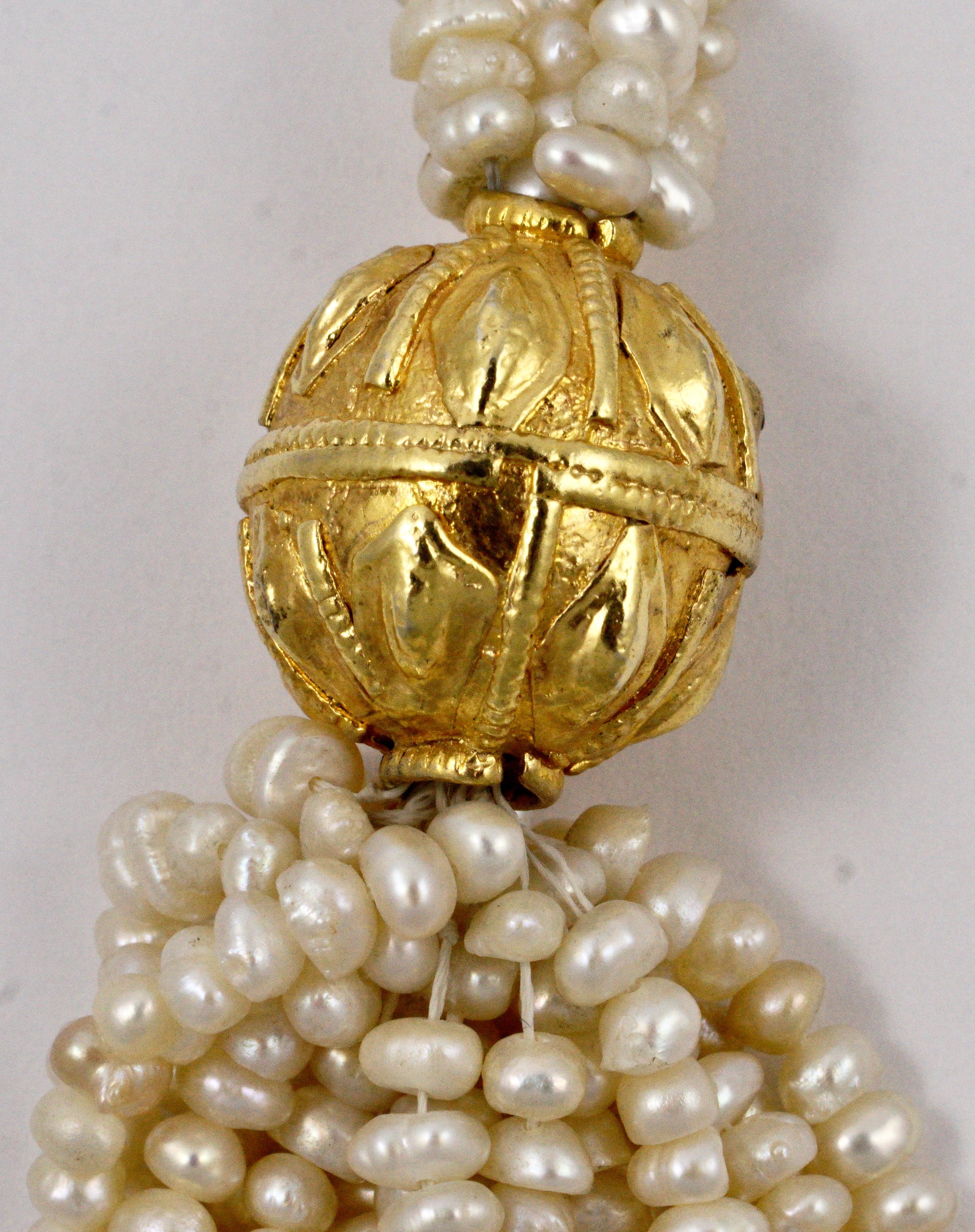 Luxurious multi strand cream freshwater pearl necklace featuring ornate gold plated balls, and a decorative golden clasp. The main part of the necklace has sixteen strands of pearls, reducing to six strands towards the clasp. The necklace is in very