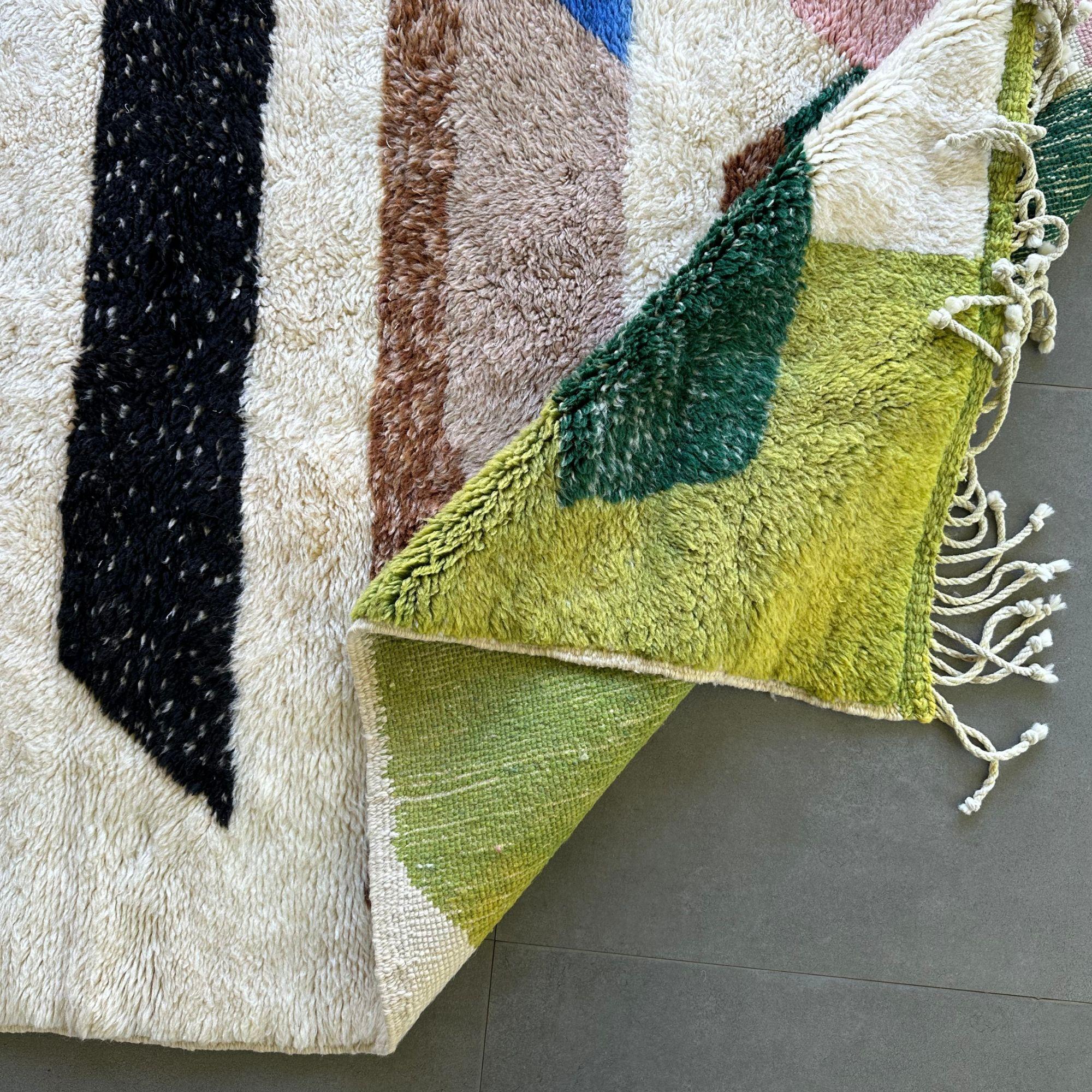 Introducing the Berber Harmony, a captivating contemporary Moroccan rug that adds a vibrant artistic flair to any space. This exquisite rug features a pristine white base with a striking multicolor design in green, pink, brown, black, and blue.