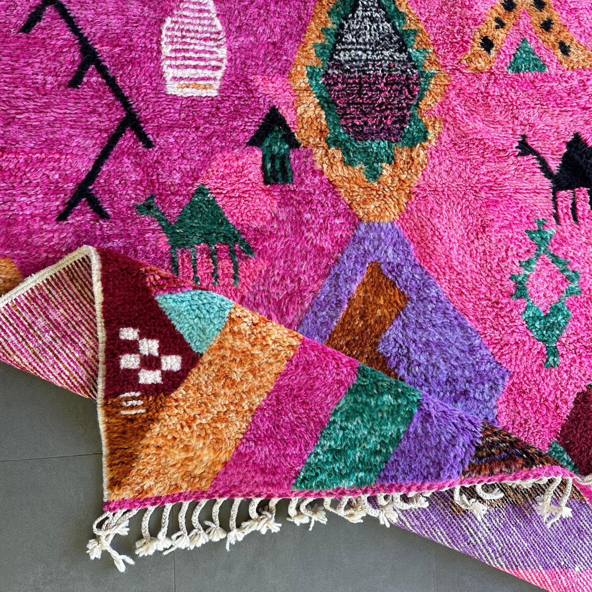 Presenting the Desert Dance, an exquisite handmade wool rug that radiates vibrant artistry and Berber heritage. This stunning rug, dominated by a pink hue, features an intricate design inspired by the secret language of Berber women. Accented with