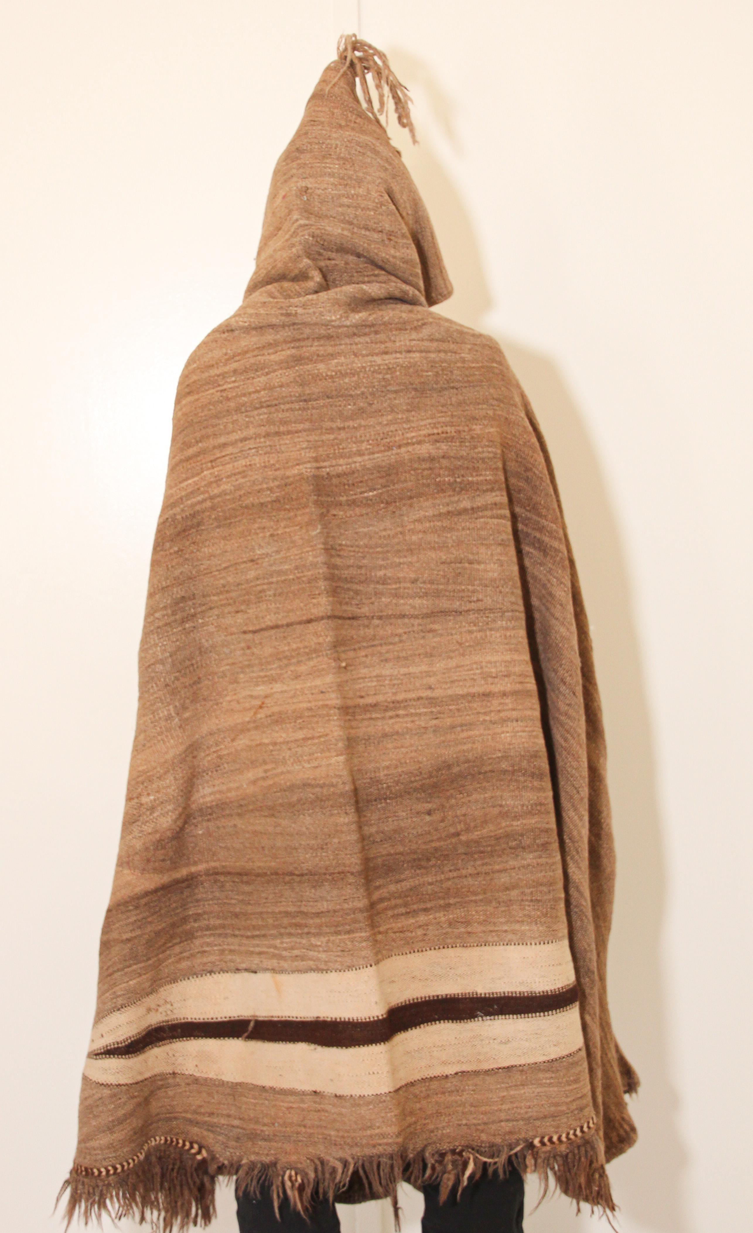 Moroccan Akhnif Berber hooded burnous cape in handwoven brown wool.
Tribal traditional cape with hood handwoven in the High Atlas Mountains.
Tribal Folk Art design in the back, great shades of brown natural organic wool colors.
The burnus (also