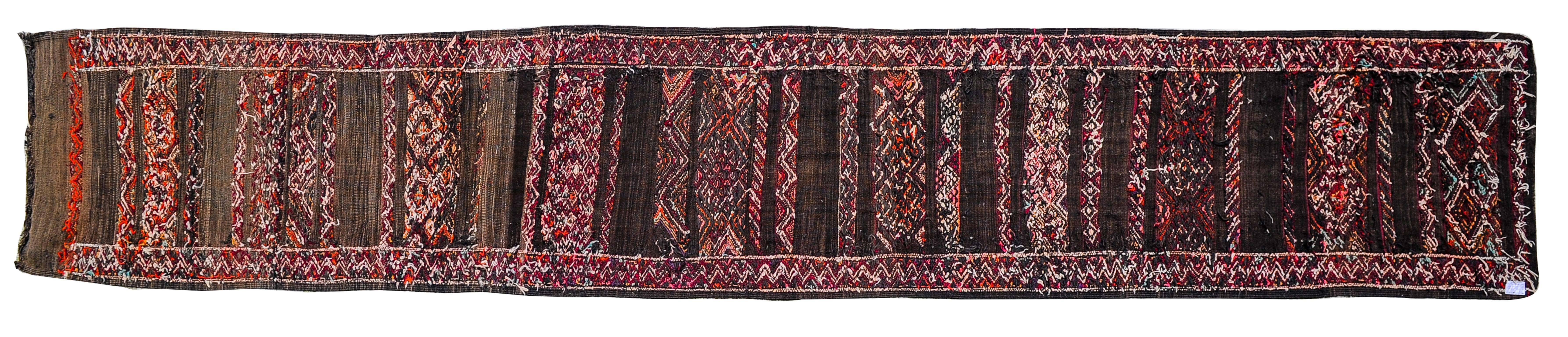 Vintage Moroccan Nomadic runner, very long, with geometrical archaic design.
The black color was used for wool by nomads to rest their eyes in the strong light of the desert sun.
These rugs are used in the Berber tents, light for easy travel for