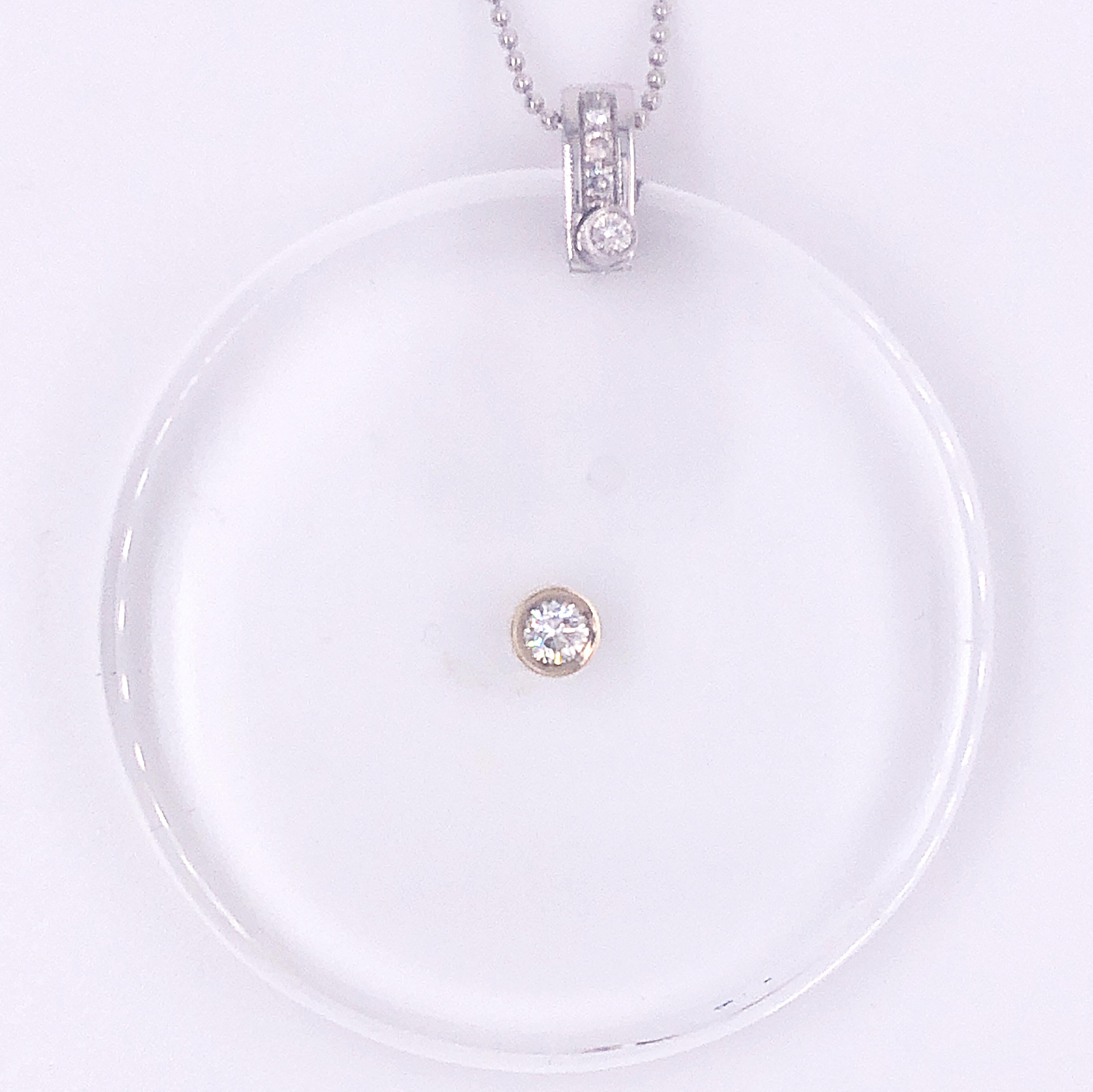 A very chic, timeless, yet not traditional Round Shaped Pendant featuring a 0.28kt Brilliant Cut White Diamond in a transparent rock crystal hand inlaid disk, 18k white gold handcrafted setting. A dark leather long ribbon is included.
A fitted beige