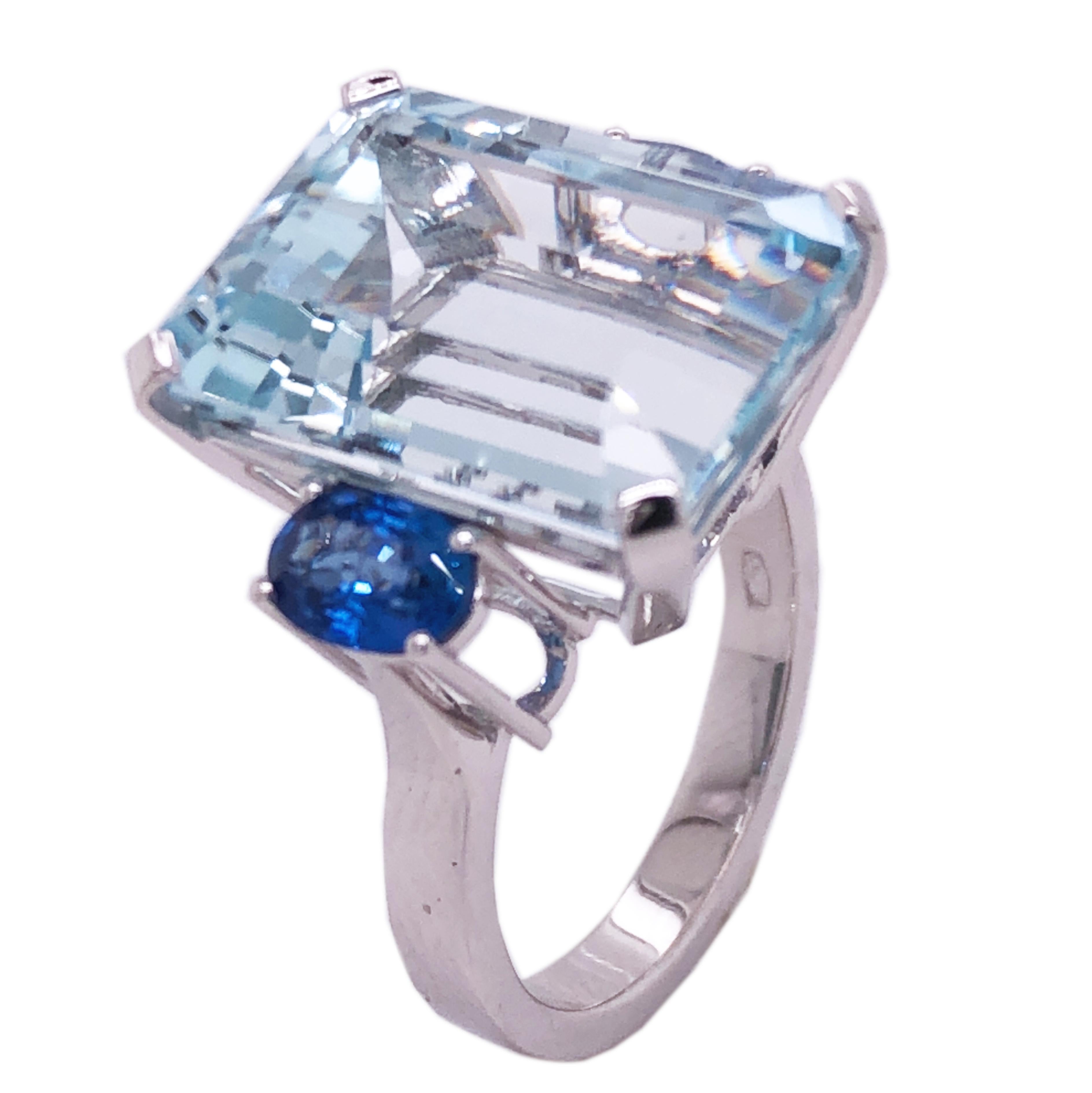 One-of-a-kind 12 Carat Emerald Cut Natural Brazilian Aquamarine(0.65in lenght 0.47in width, 16.5x11.9mm) in a Chic yet Timeless two 1.09 CaratNatural Ceylon Oval Blue Sapphire 18Kt White Gold Cocktail Setting.
We are proud to offer this awesome