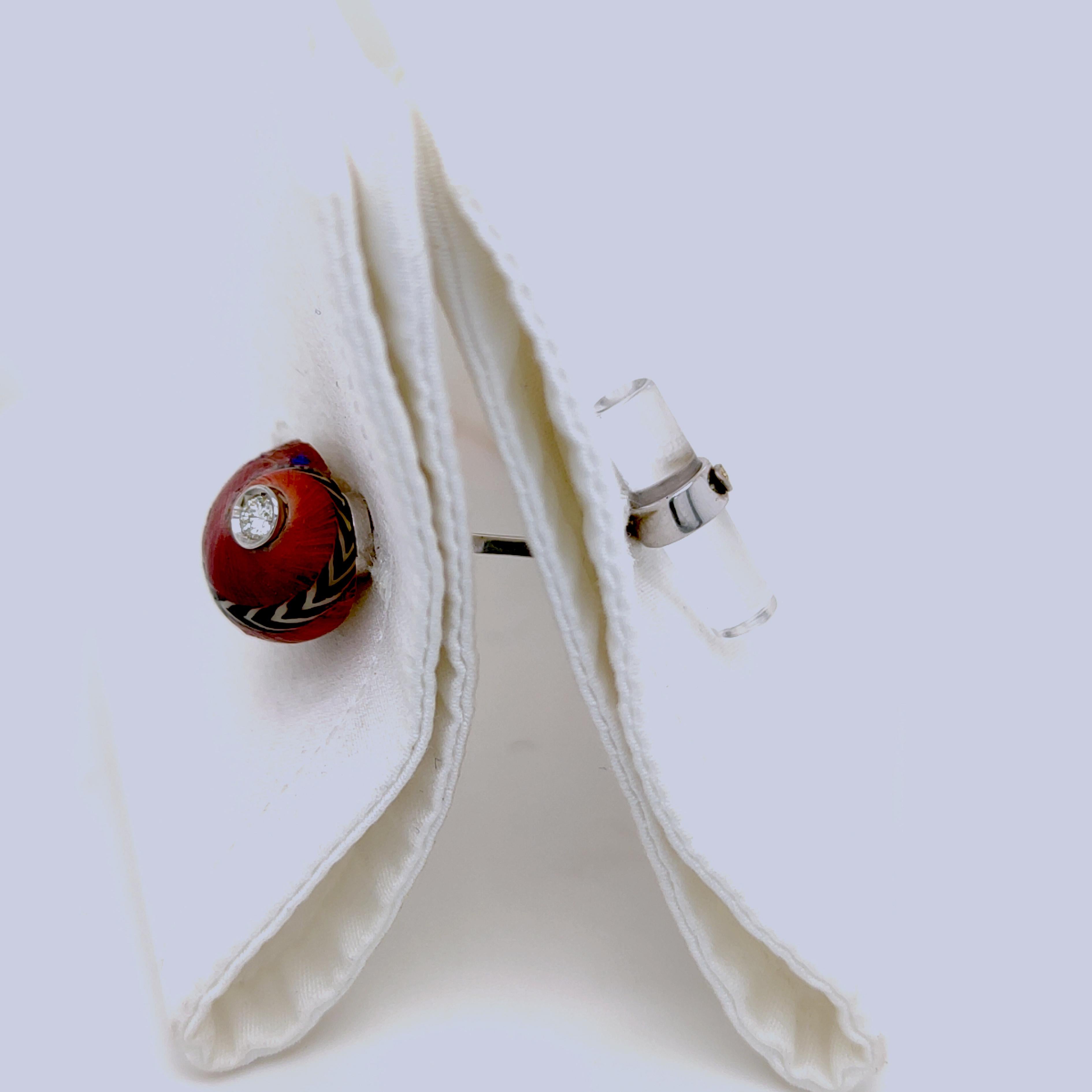 Une paire de boutons de manchette unique en son genre présentant un diamant blanc de qualité supérieure taillé en brillant dans un coquillage de mer rouge, noir et blanc en forme de nacre reconstituée, émaillé à la main, sur une monture en or blanc.