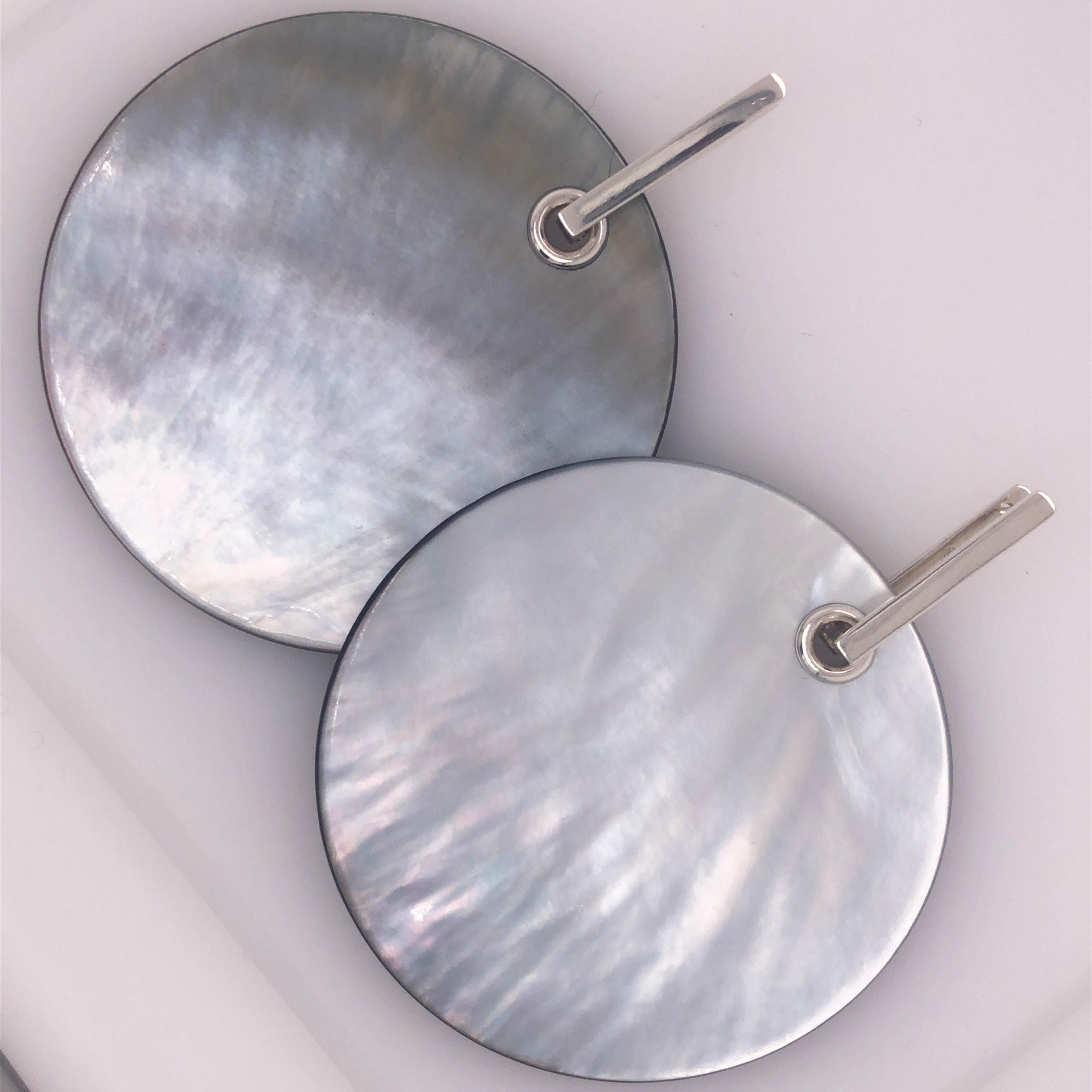 Einzigartige, absolut schicke, abnehmbare, hellgraue, handemaillierte Perlmuttscheibe (2,5 Zoll, 6,5 cm Durchmesser) in einer modernen, minimalistischen Sterlingsilberfassung.
Die Scheiben können beidseitig getragen werden, auf der Rückseite mit