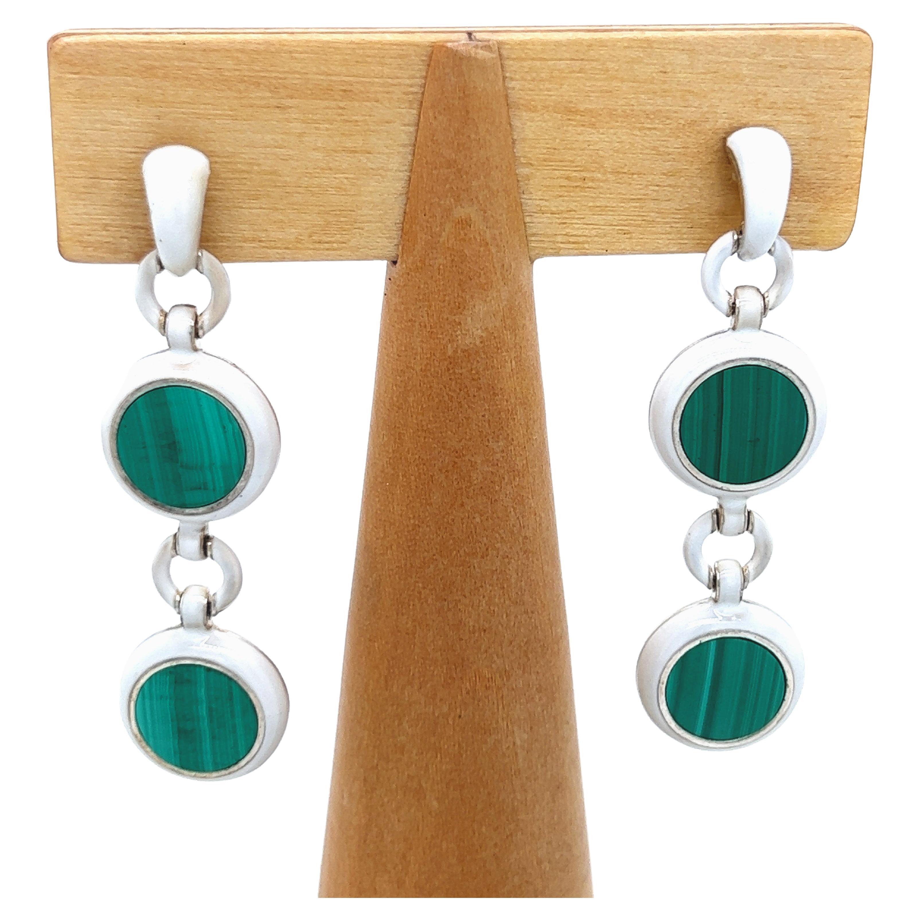 Chic yet Timeless Dangle Earrings Featuring 5Carat Natural Hand Inlaid Round Malachite Disk in a White Hand Enameled Sterling Silver Setting.
In our Precious Handcrafted tobacco Suede Leather Box.


Total Lenght 1.968 inches, 5cm