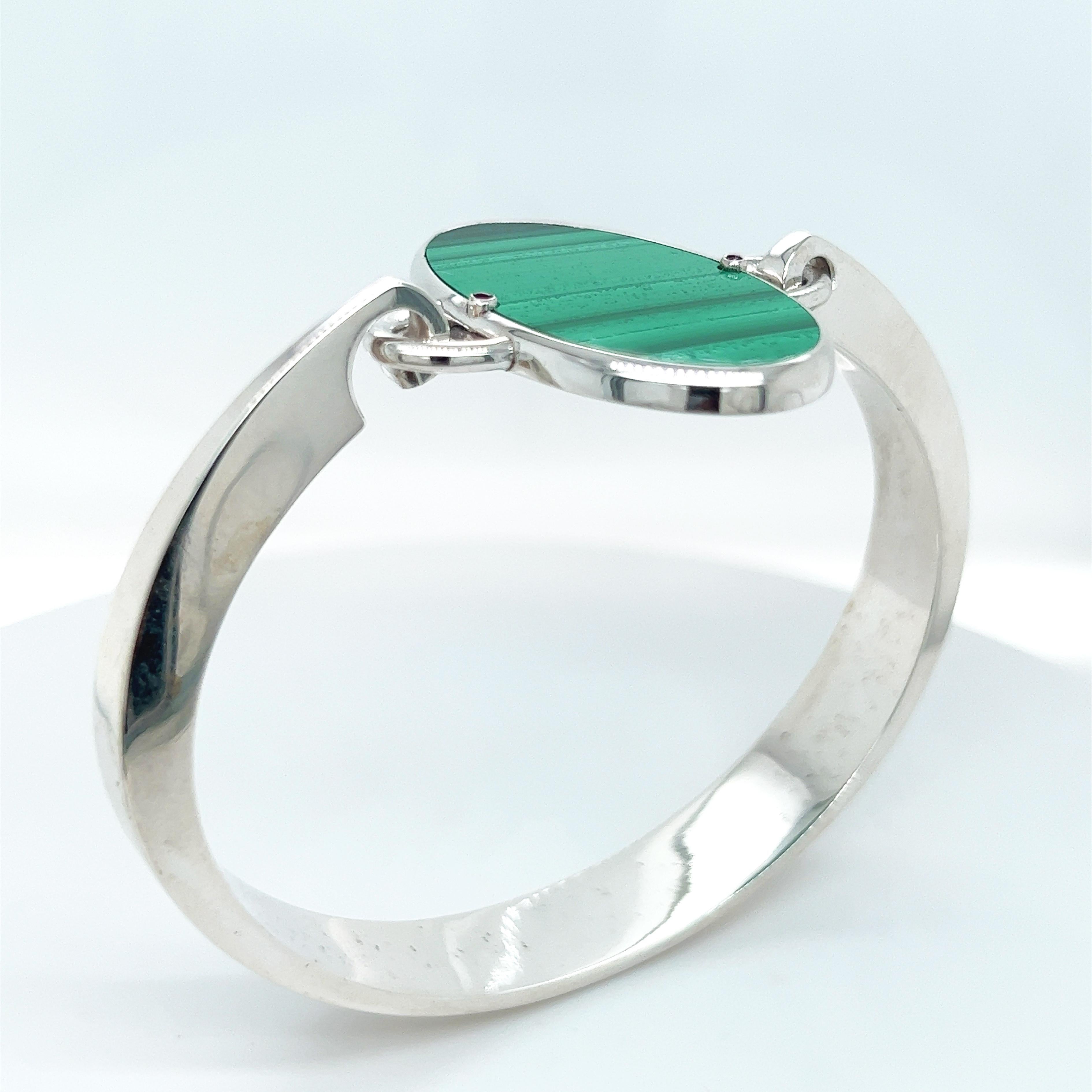 Chic yet Timeless, a contemporary classic Piece, Natural Hand Inlaid Malachite Oval Cut, two natural round ruby in a Solid Handcrafted, Sterling  Silver Bangle Bracelet Setting. 
In our smart Tobacco suede Leather Box and Pouch.
Bracelet Weight: