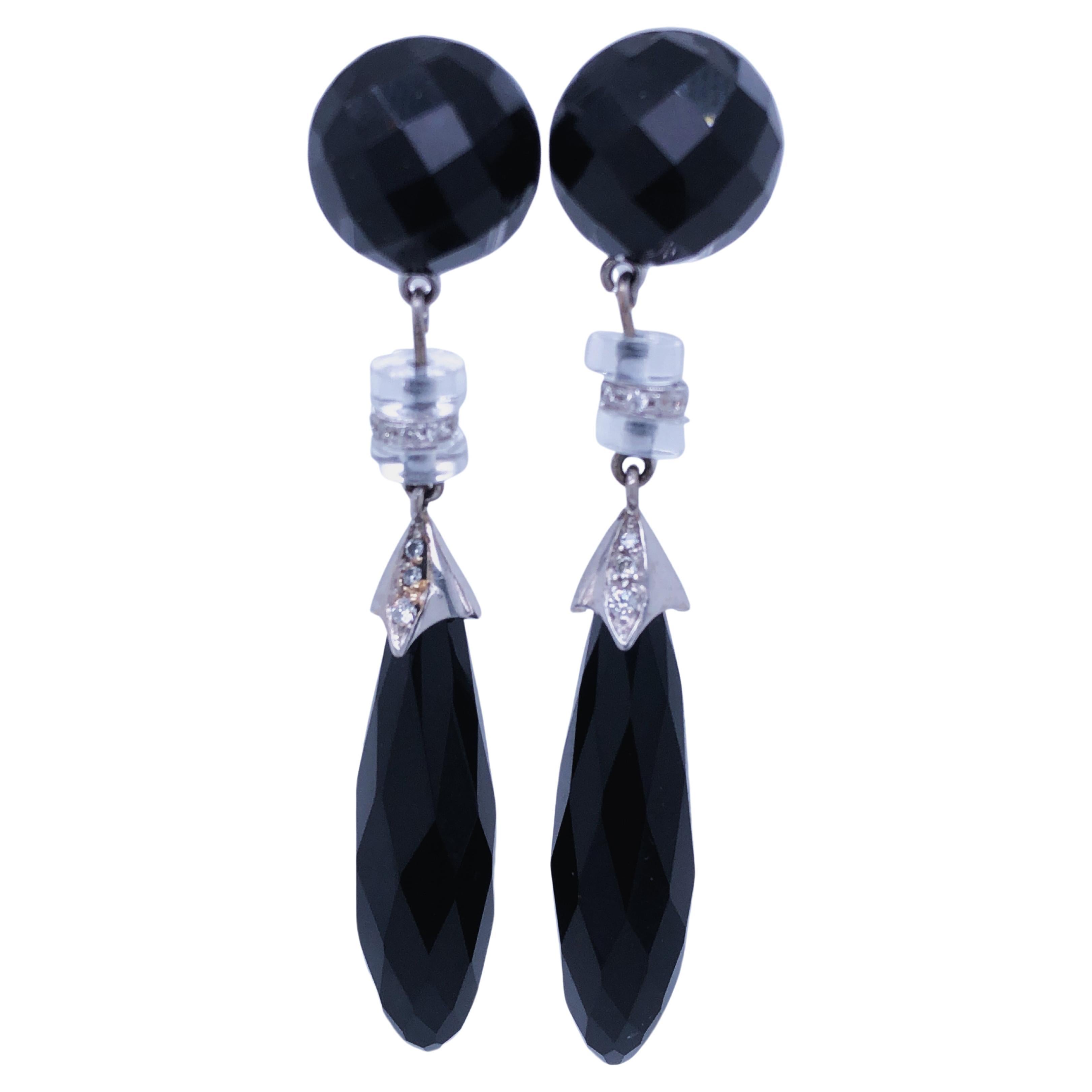 One-of-a-kind Chic yet Timeless Drop Earrings featuring 50Kt Hand Inlaid Natural Round Cabochon and Drop Faceted Cut Onyx in a 0.40Kt White Diamond and Rock Crystal disk 0.154 OzT 18K White Gold Setting.
In our smart fitted tobacco suede leather