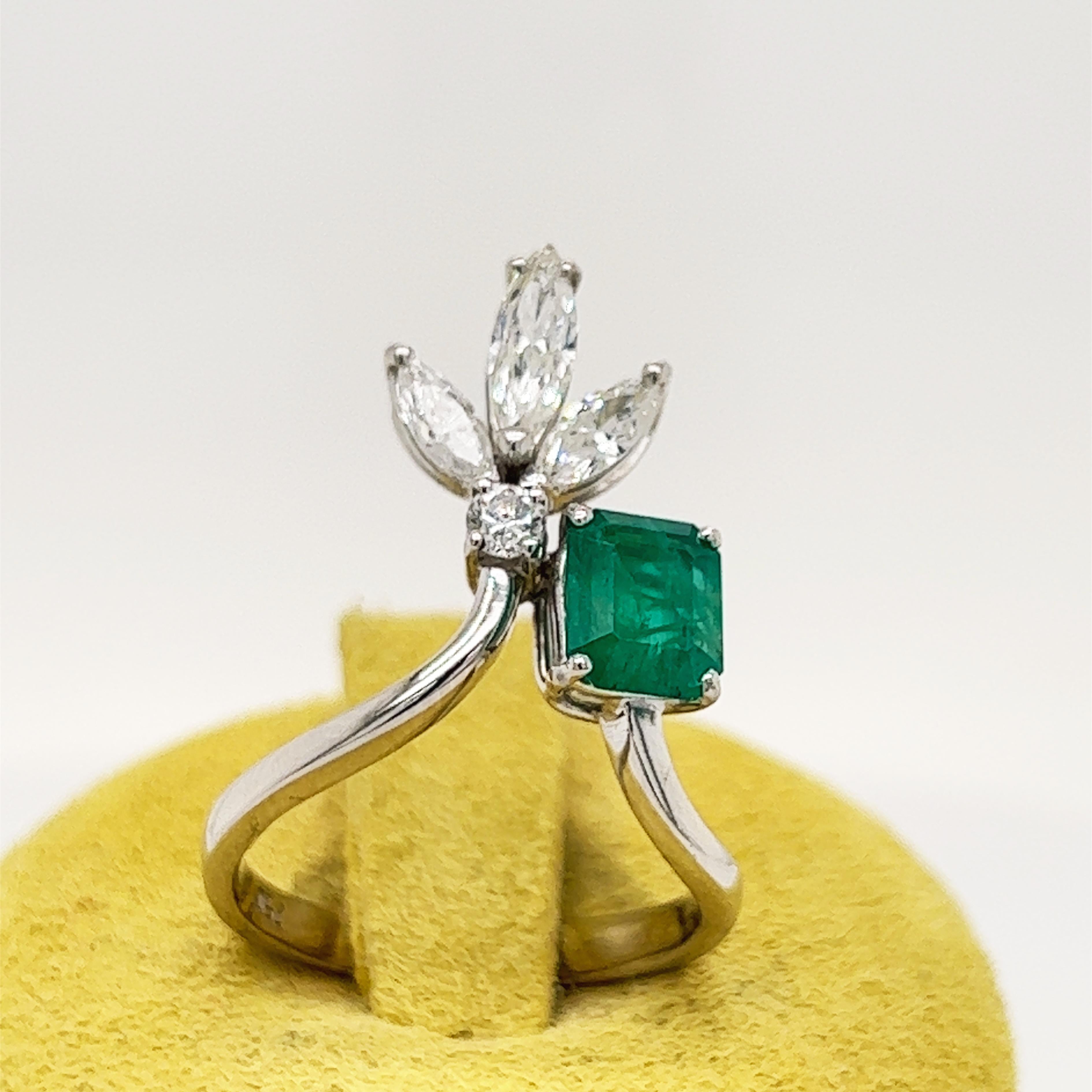 Une bague de cocktail chic, unique en son genre, fabriquée à la main en 1970, avec une émeraude de Muzo de 0,82 carrée dans une monture en or blanc de 0,39 carats, avec un diamant blanc de taille marquise et brillante.
Un certificat gemmologique