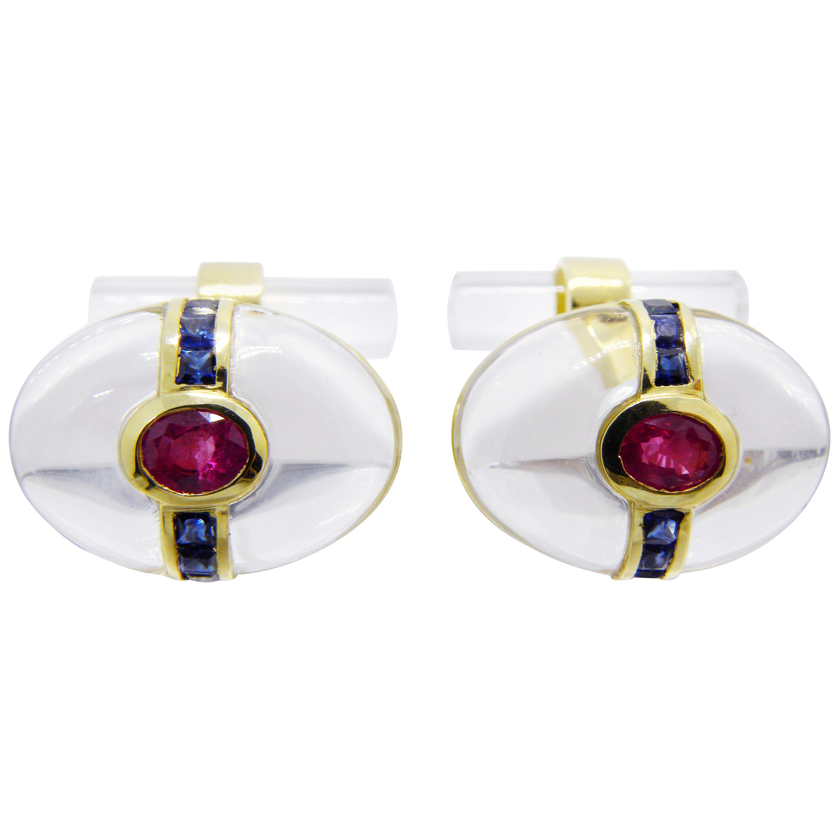 One-of-a-kind, absolutely Chic yet Timeless pair of Cufflinks featuring an Oval Hand Inlaid Transparent Rock Crystal Cabochon embracing a Natural Oval Ruby and an almost One Carat Blue Sapphire Calibré Cut Line in an 18K Yellow Gold Setting. 
A Rock