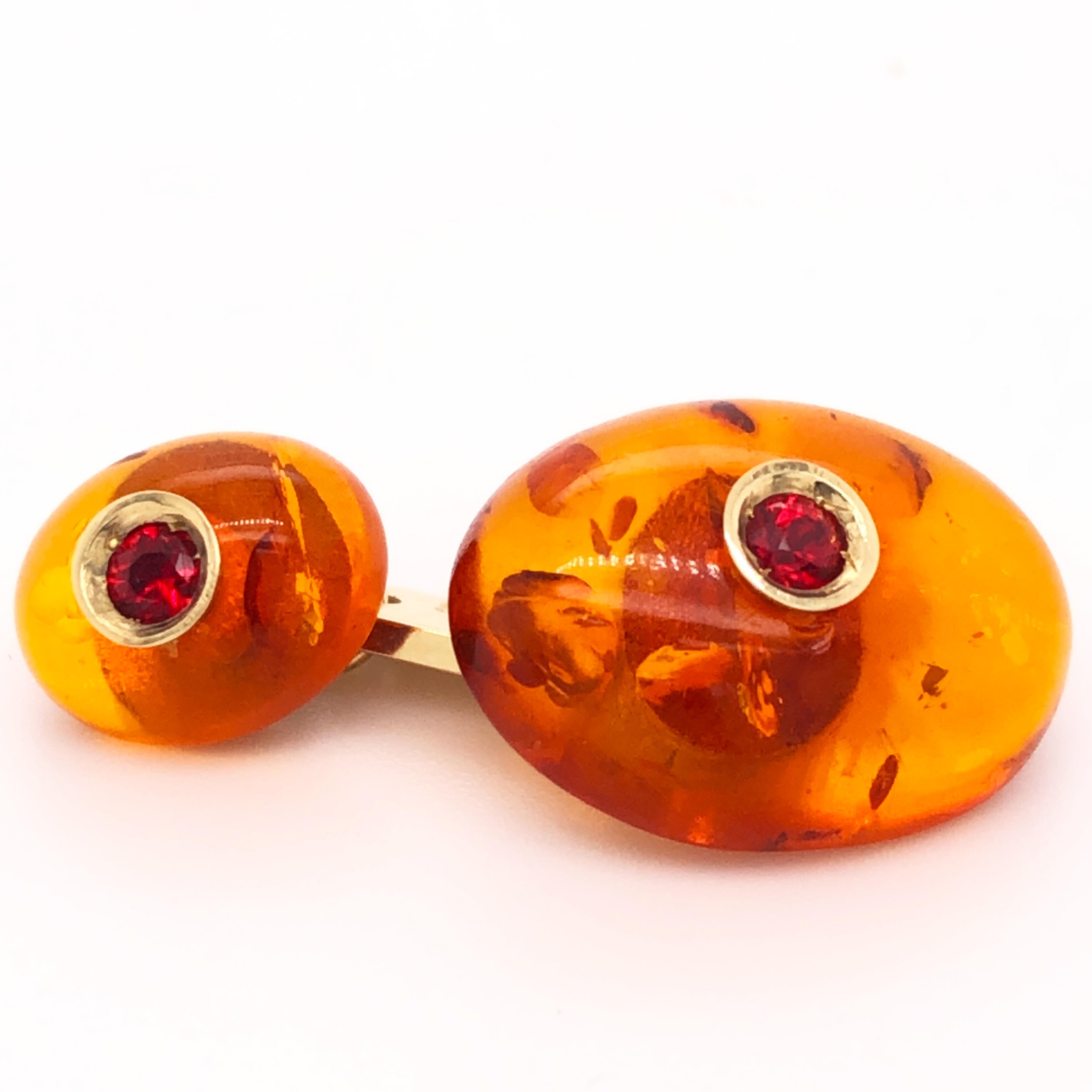 Absolutely Chic, Classy yet Timeless Oval Shaped Hand Inlaid Natural Amber Cufflinks featuring four natural 0.33 Carat Brilliant Cut Ruby in a Yellow Gold setting.

In our smart fitted Tobacco Leather Case and Pouch.
