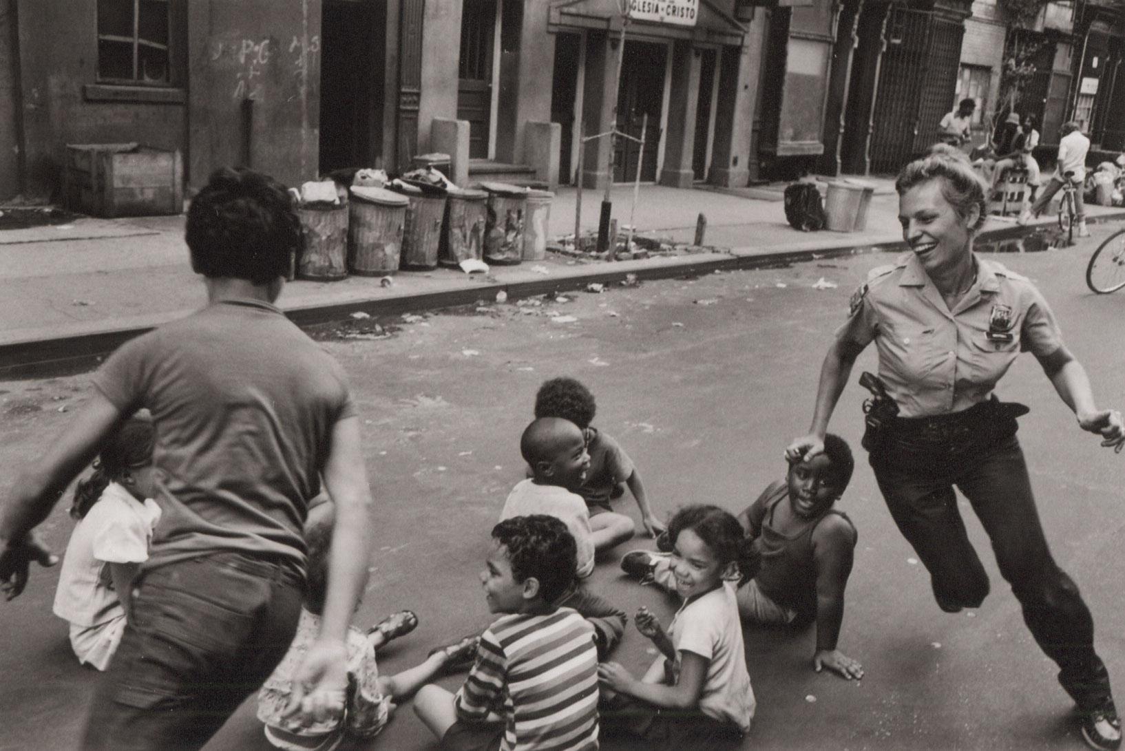 A policewoman plays with local kids in Harlem, New York City, USA, 1978 - Photograph by Leonard Freed